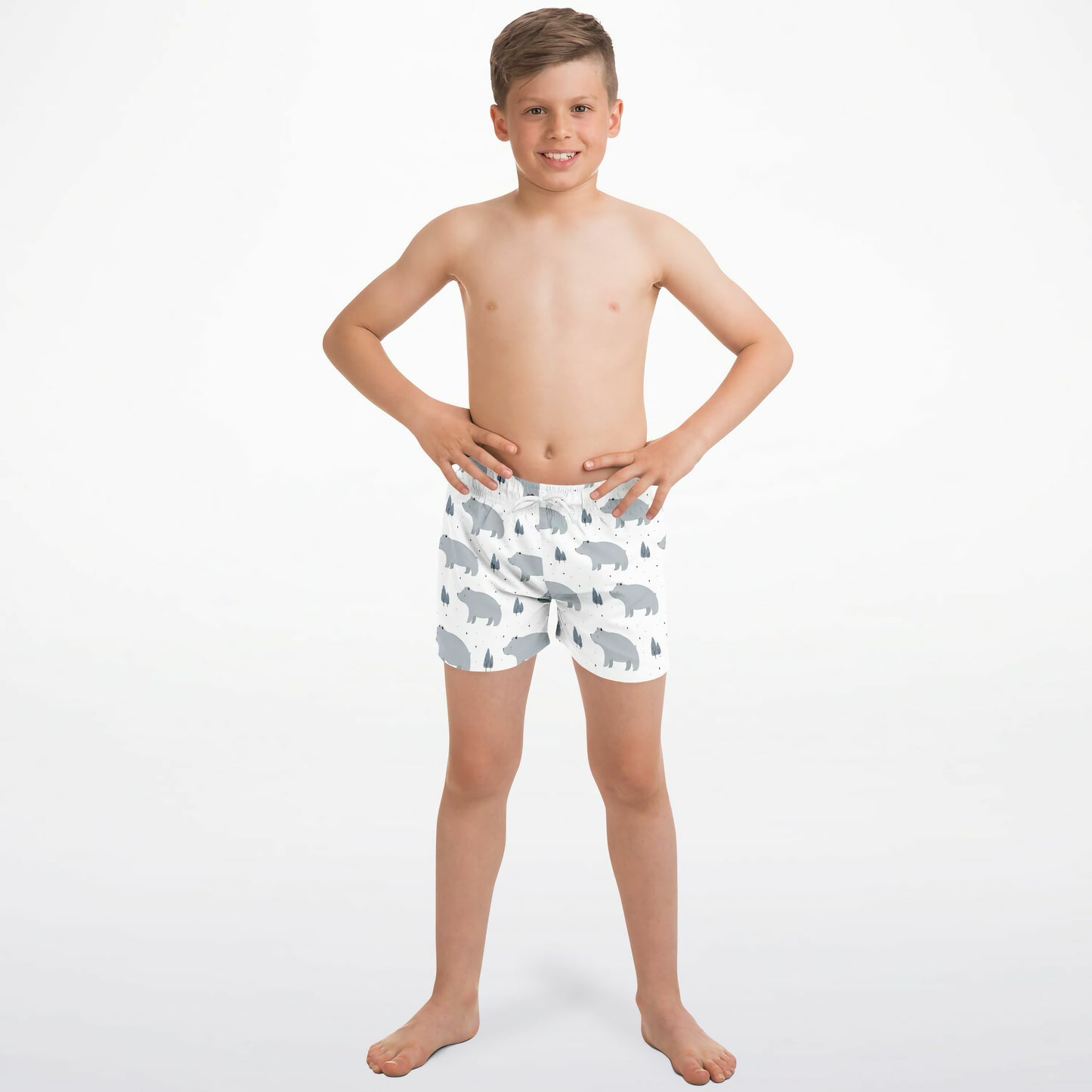 Young boy wearing bear patterned shorts on a white background