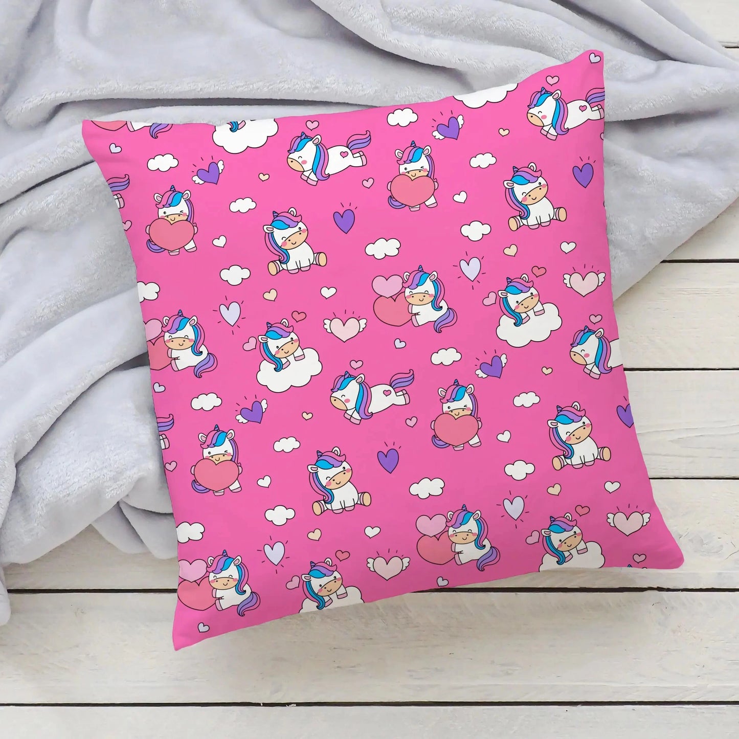 pink pillow with unicorns and hearts on it