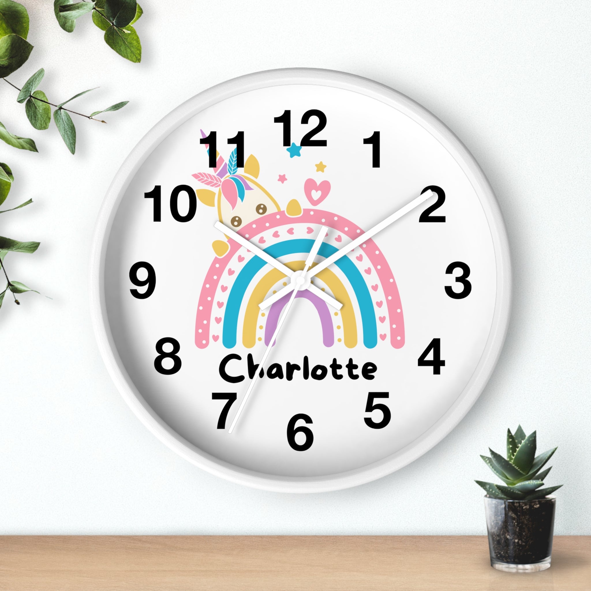 A white round silent wood wall clock with pastel rainbow stripes and a custom name charlotte featuring a unicorn design