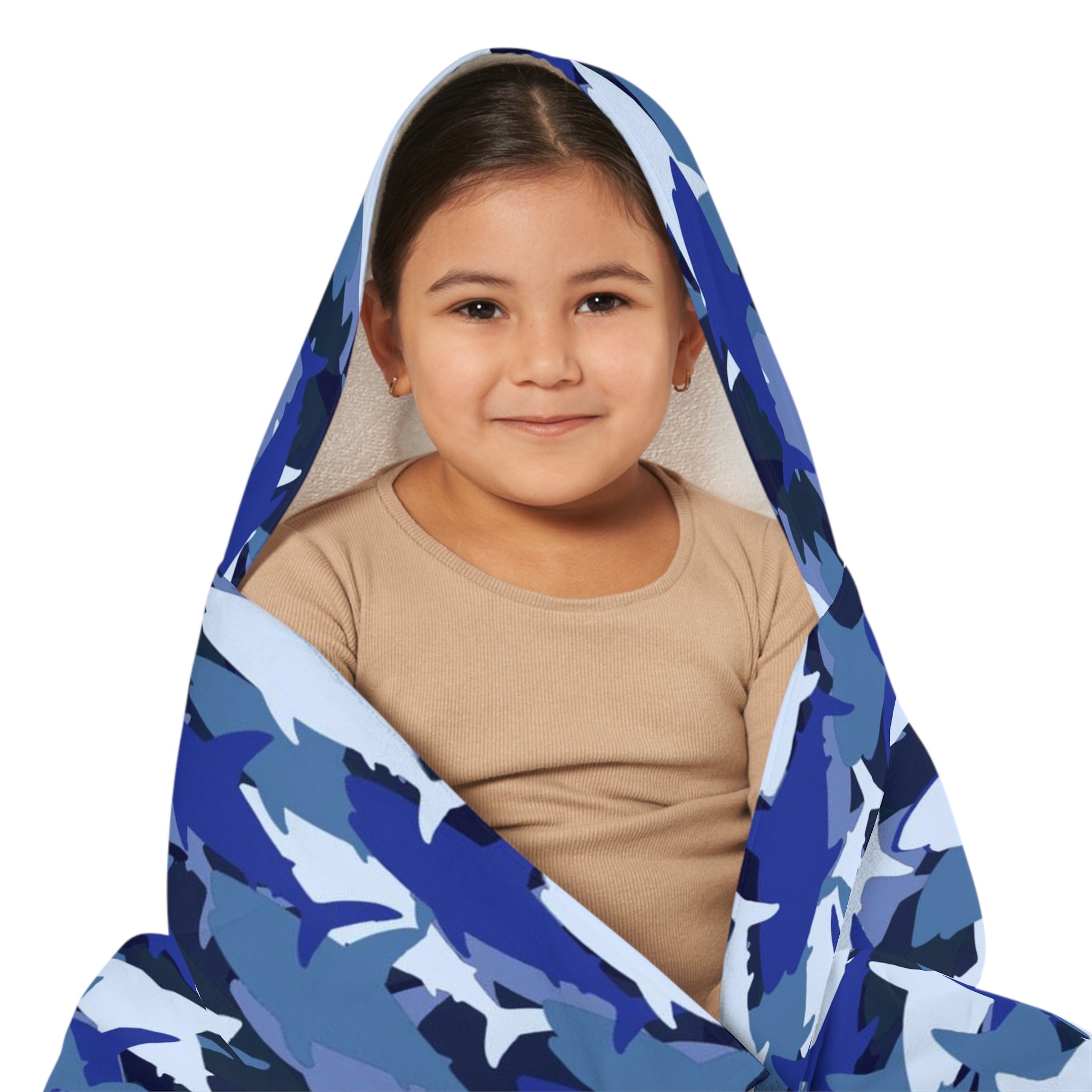 A child wrapped in a kids blue shark hooded towel made of soft and absorbent fabric for bath and beach use