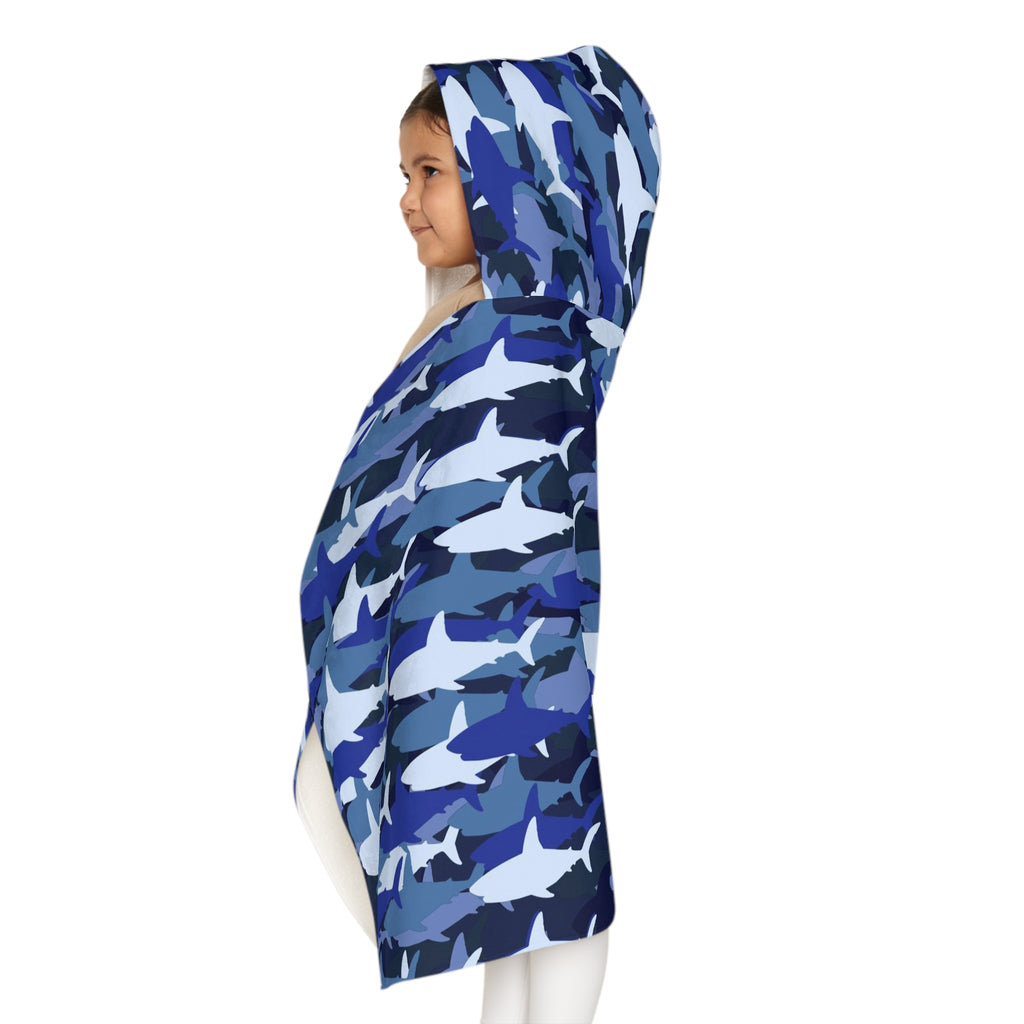 A child wearing a kids blue shark hooded towel made of soft absorbent material for bath and beach use