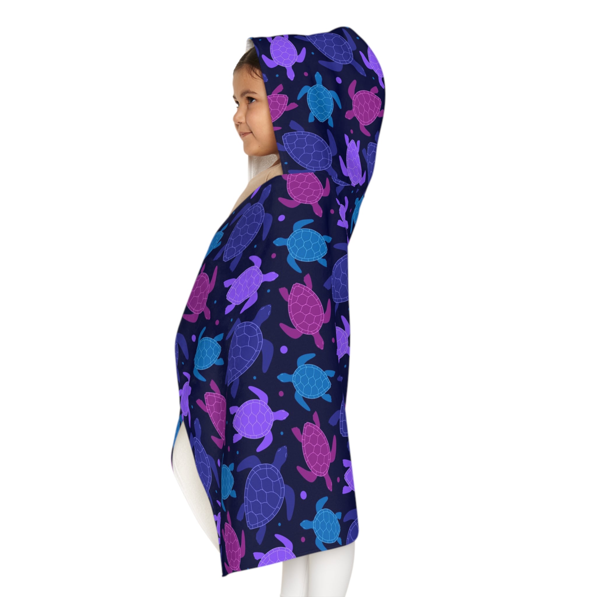 A child wearing a soft, absorbent navy blue hooded towel with purple and pink sea turtles for beach and bath time