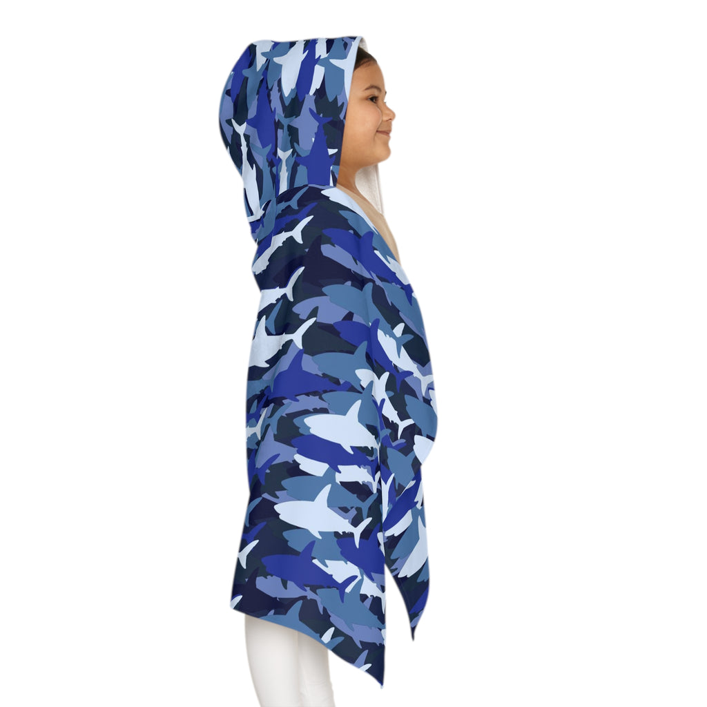A child wearing a soft and absorbent kids blue shark hooded towel with white shark camouflage for bath and beach use
