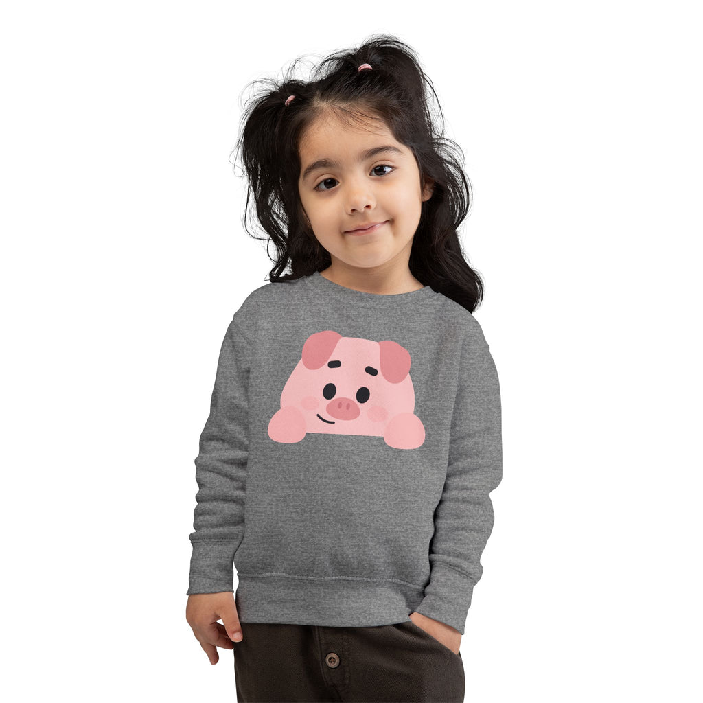 Child wearing a gray sweatshirt with a pink pig design on a white background