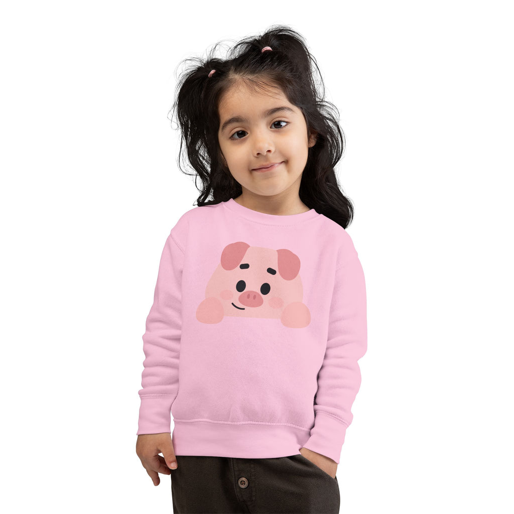 Child wearing a pink sweatshirt with a pig design on a white background