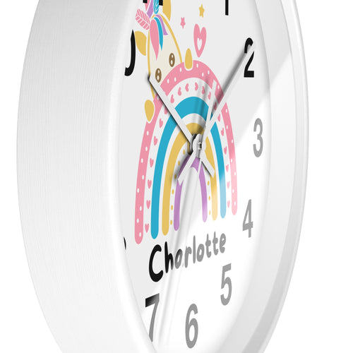 A white round wood wall clock with a colorful unicorn rainbow design and the name charlotte for girls room decor