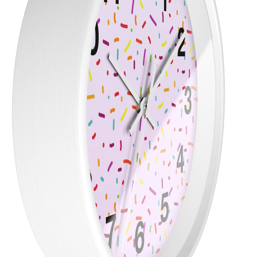 A girls colorful sprinkles silent wood wall clock with a white frame and light pink face with multicolored sprinkles