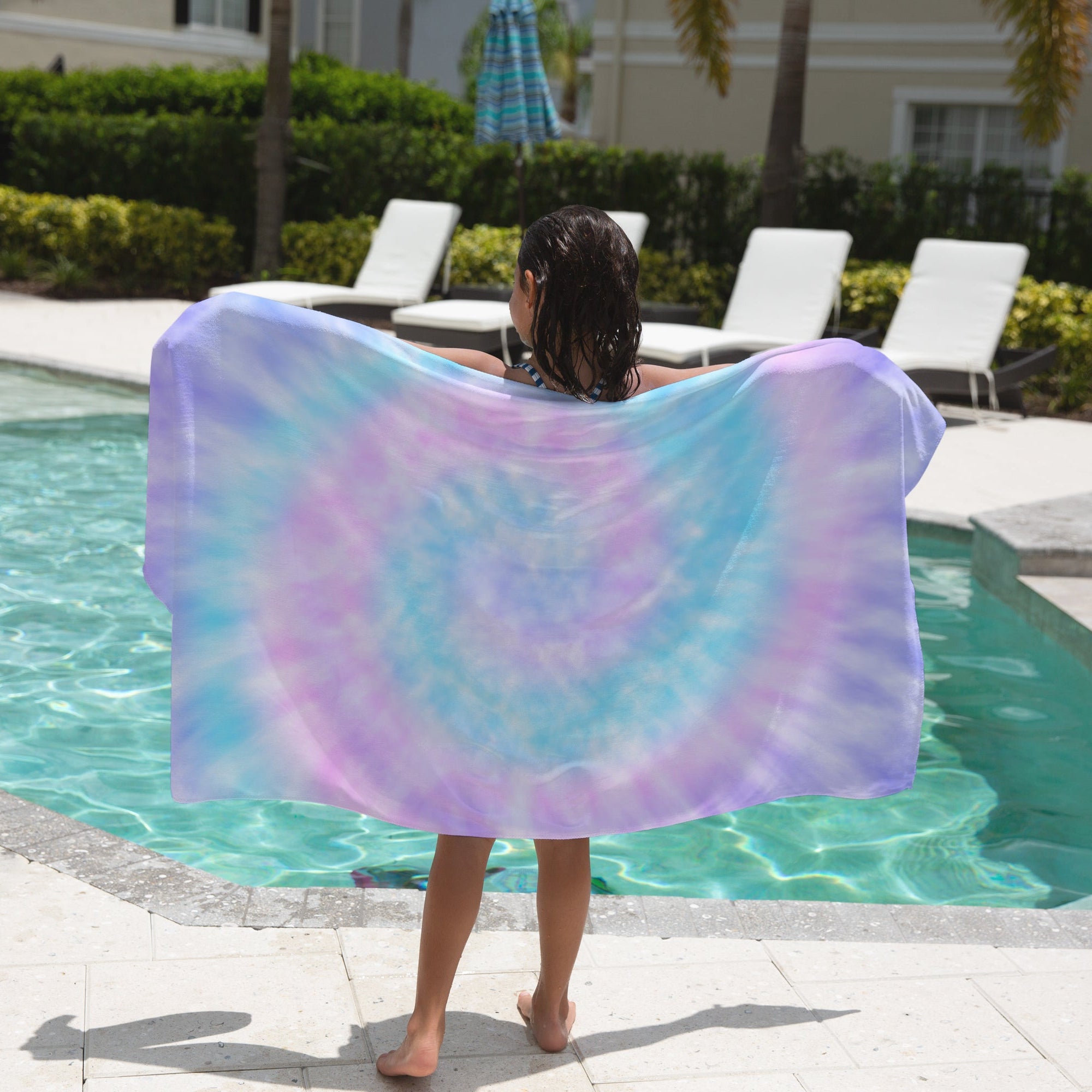 Girls tie dye towel with vibrant purple and blue swirls made of soft lightweight fabric for poolside use