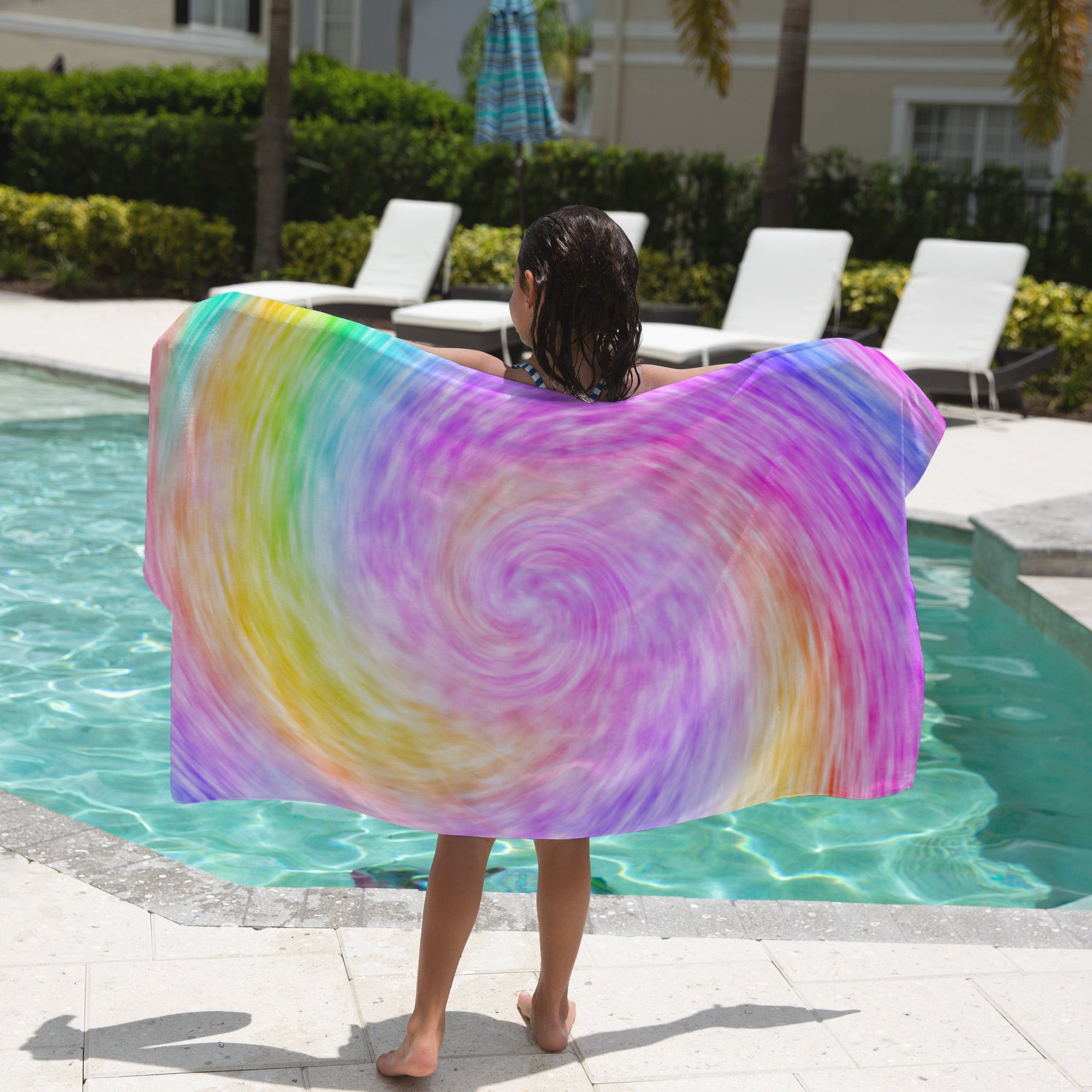 A vibrant girls faux rainbow tie dye towel with a soft flowing fabric and colorful swirl beach design