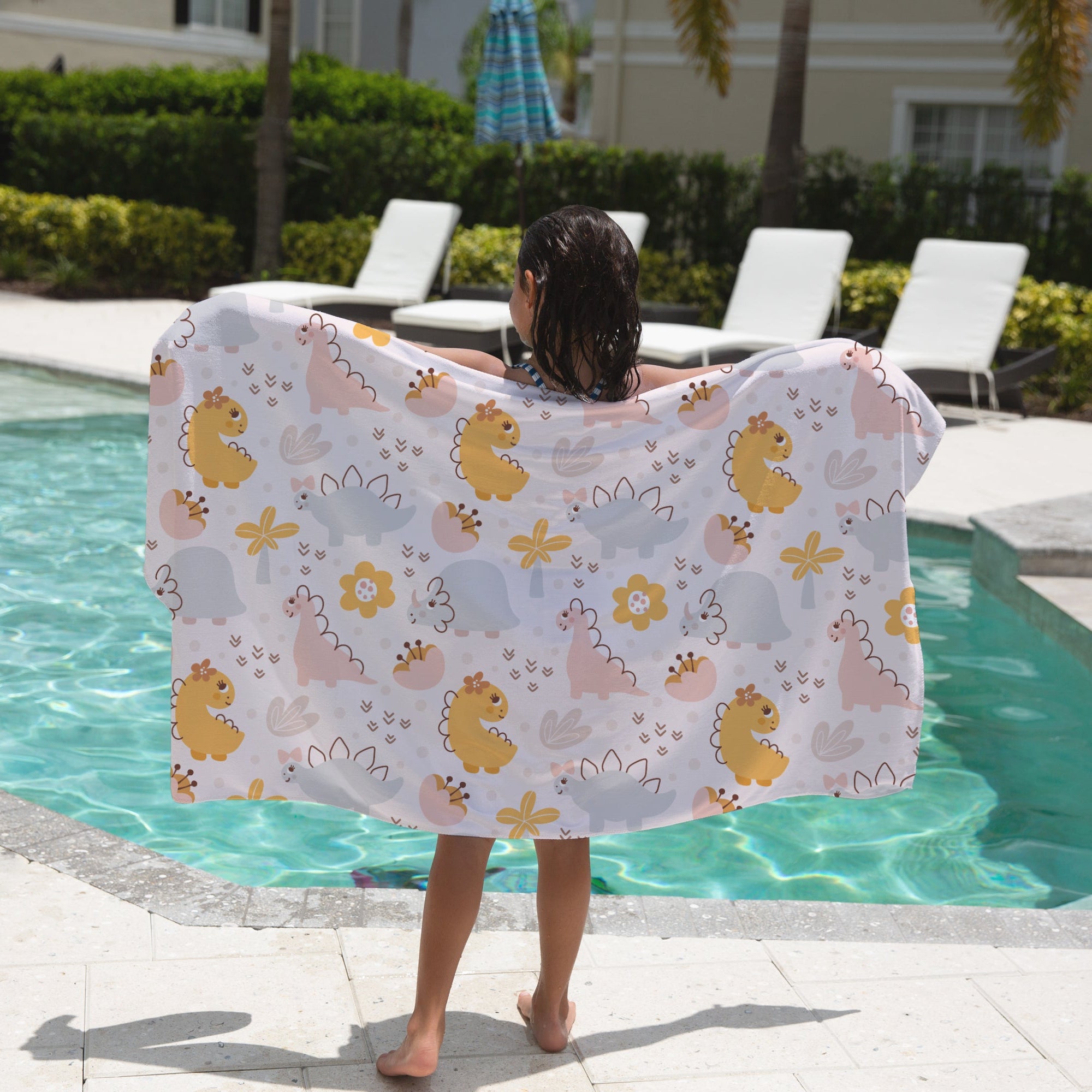 Girls floral dinosaur towel with a white base featuring yellow pink and gray cartoon dinosaurs and flowers