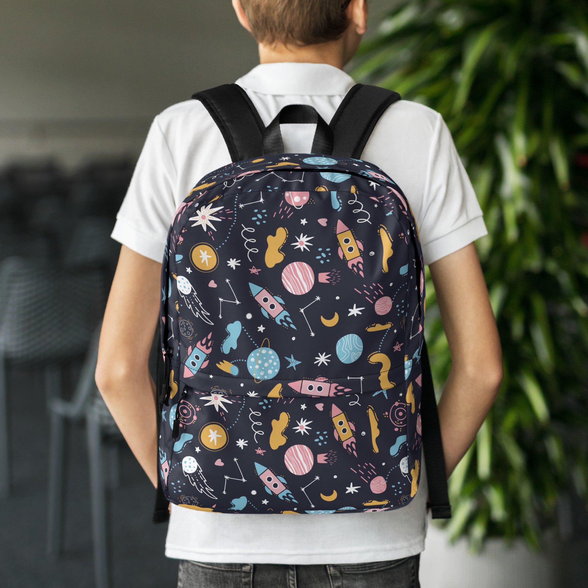 Kids outer space backpack in navy blue with playful pastel rockets planets and stars pattern for school use