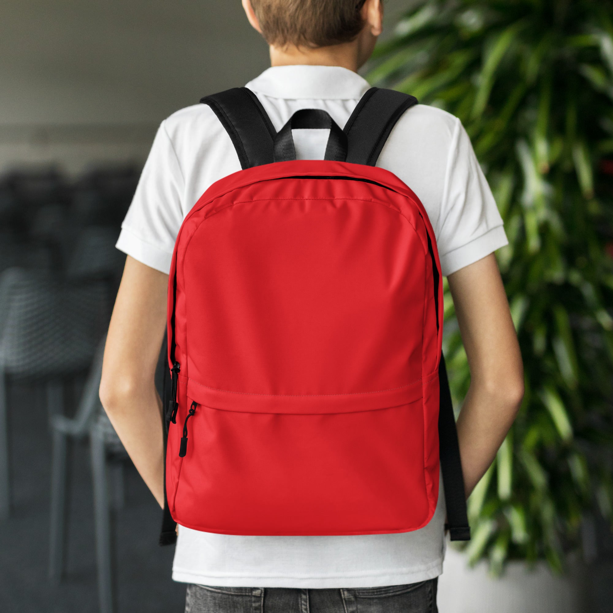 Kids red backpack made of canvas with black straps and zipper pulls for everyday use