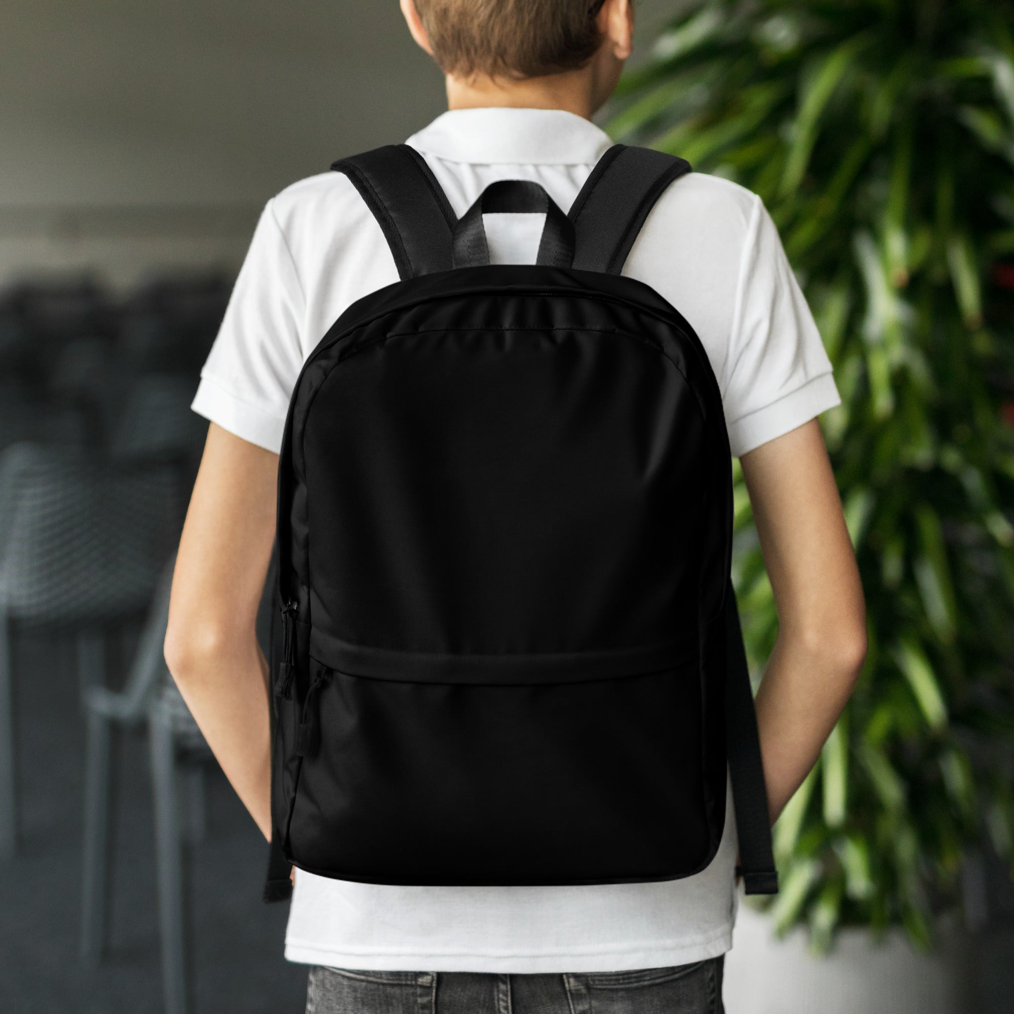Kids black backpack made of black nylon with adjustable shoulder straps and a front zippered pocket
