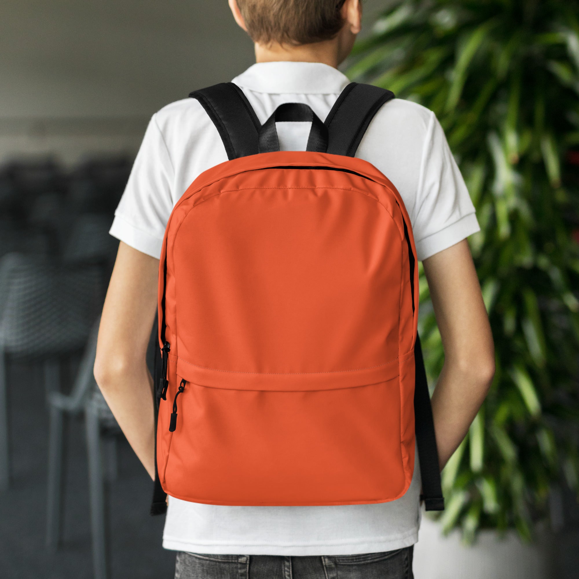 Kids orange backpack with black straps and zipper pulls made of durable material for everyday school use