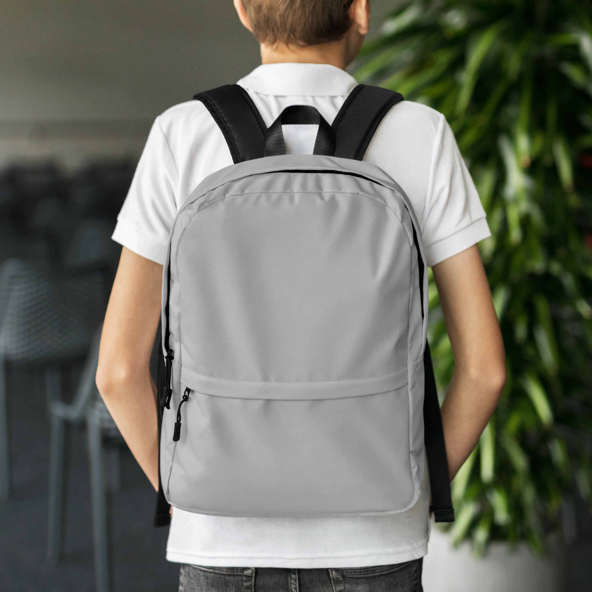 Kids gray backpack with black straps and zipper pulls shown from the back side