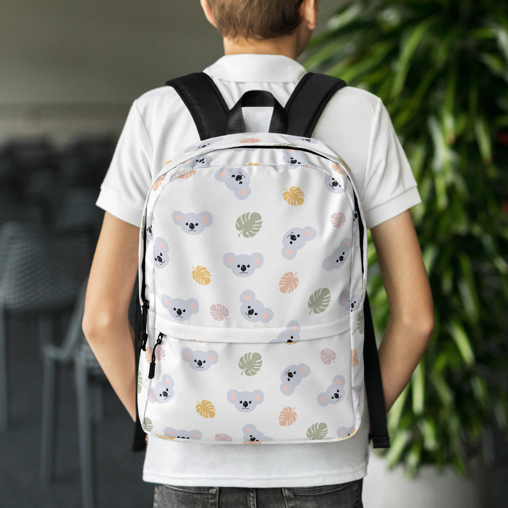 Girls koala bear backpack in white with black straps featuring a playful gray koala and pastel tropical leaf pattern