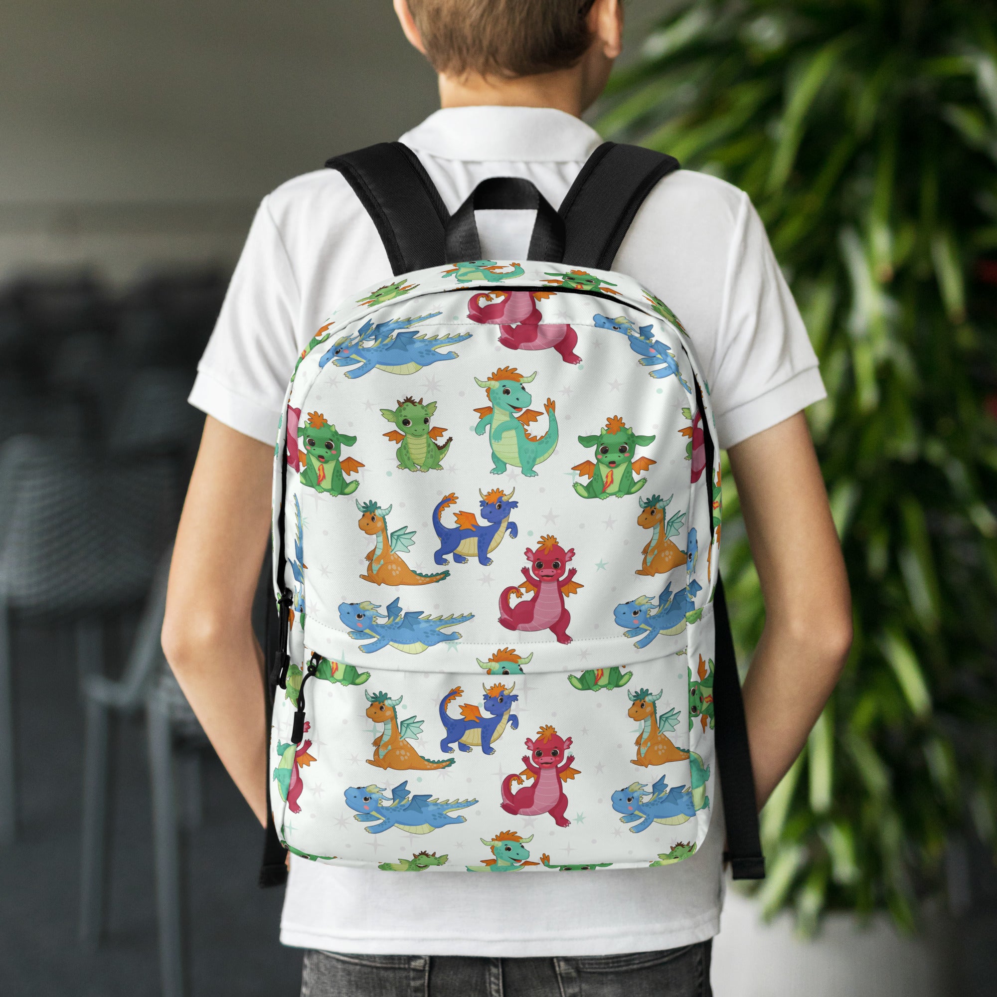 White kids cartoon dragons backpack with colorful playful dragon pattern and black straps for school use