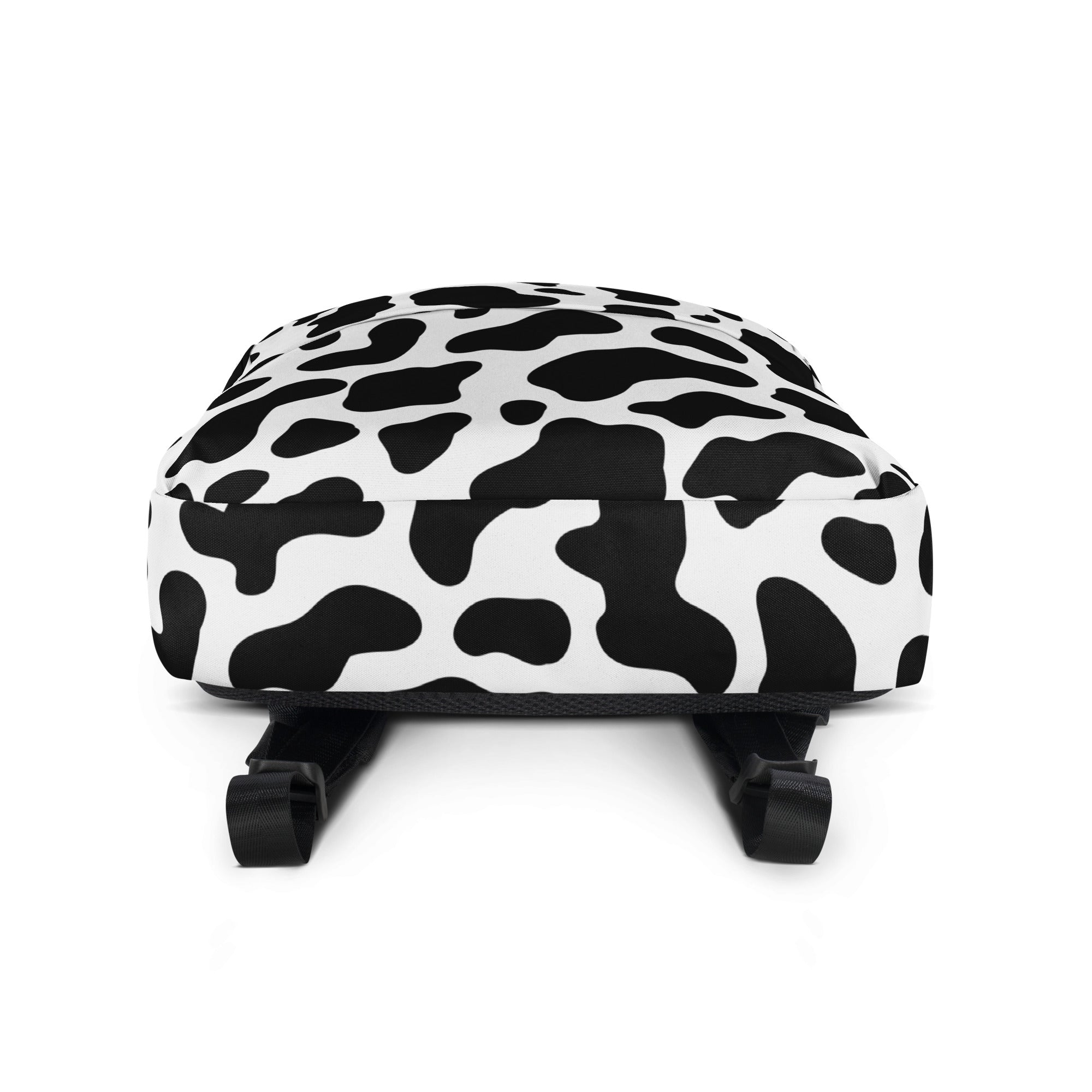 Kids cow print backpack in black and white with adjustable shoulder straps shown from the back side