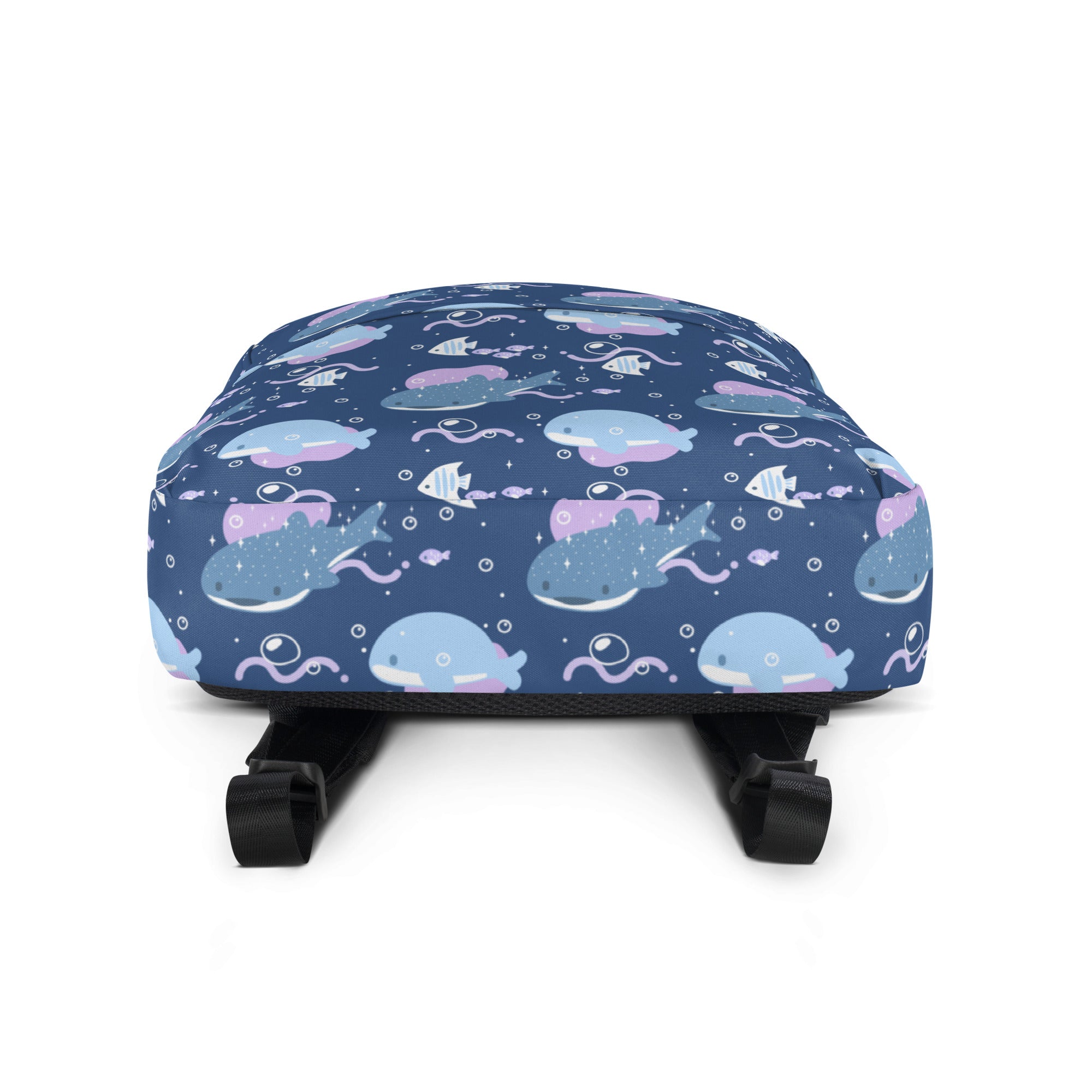 A navy blue girls whale shark backpack with a playful cartoon whale and fish pattern in light blue pink and white