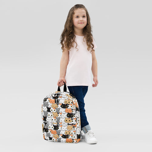 Girls cat face backpack with a playful pattern of black white orange and gray cartoon cats on a colorful fabric