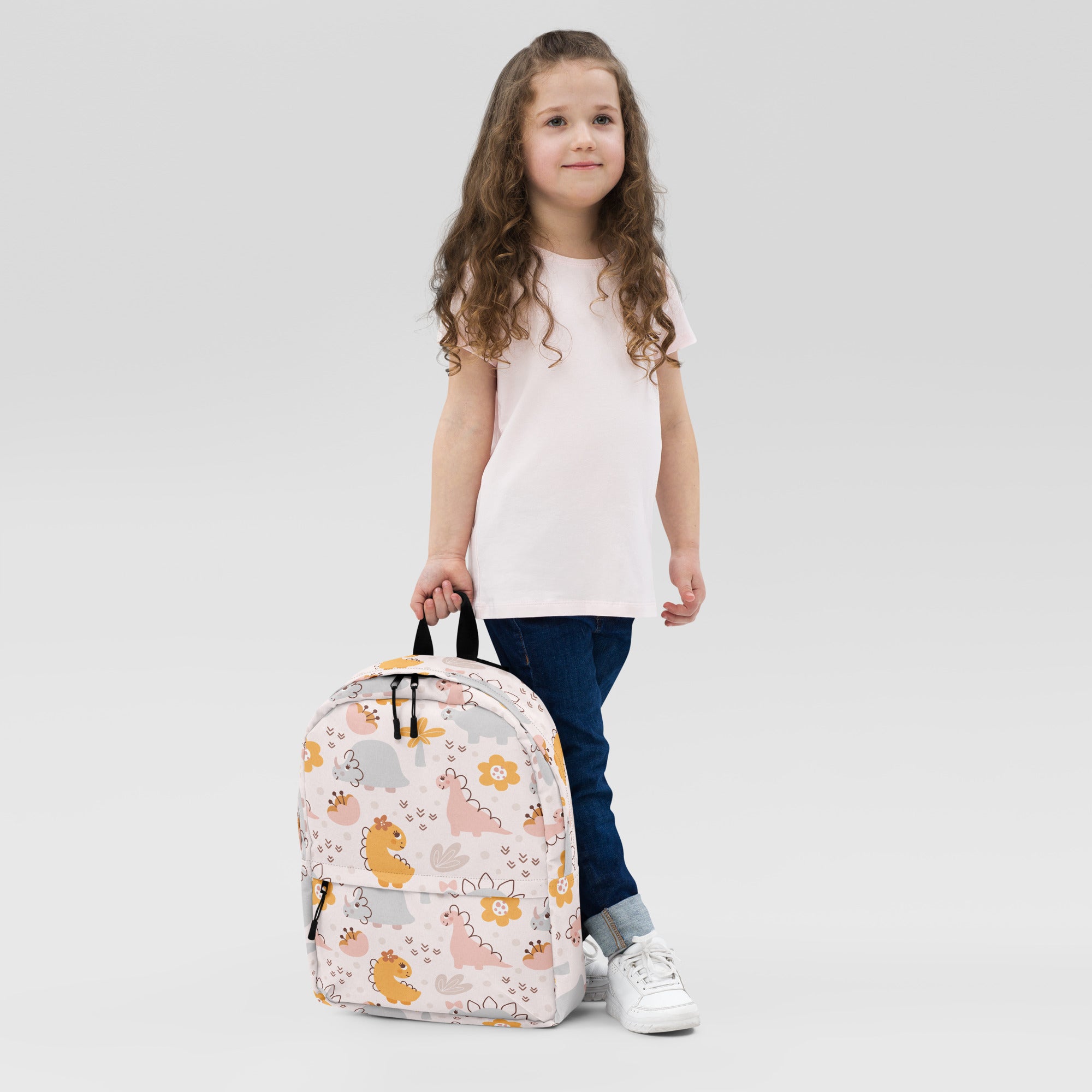 Pastel pink girls floral dinosaur backpack with playful yellow orange and gray flower and dinosaur patterns