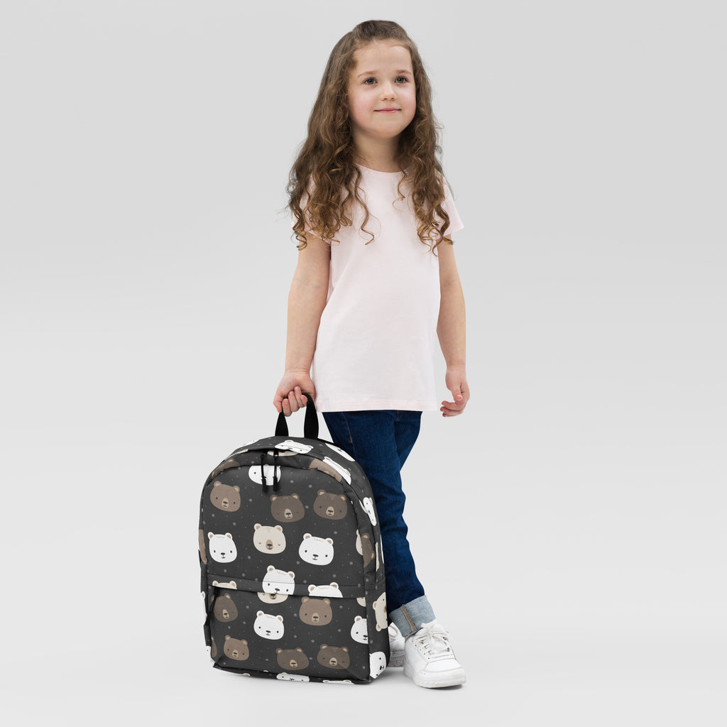 Kids bear faces backpack is a black backpack with a playful pattern of brown and white cartoon bear faces