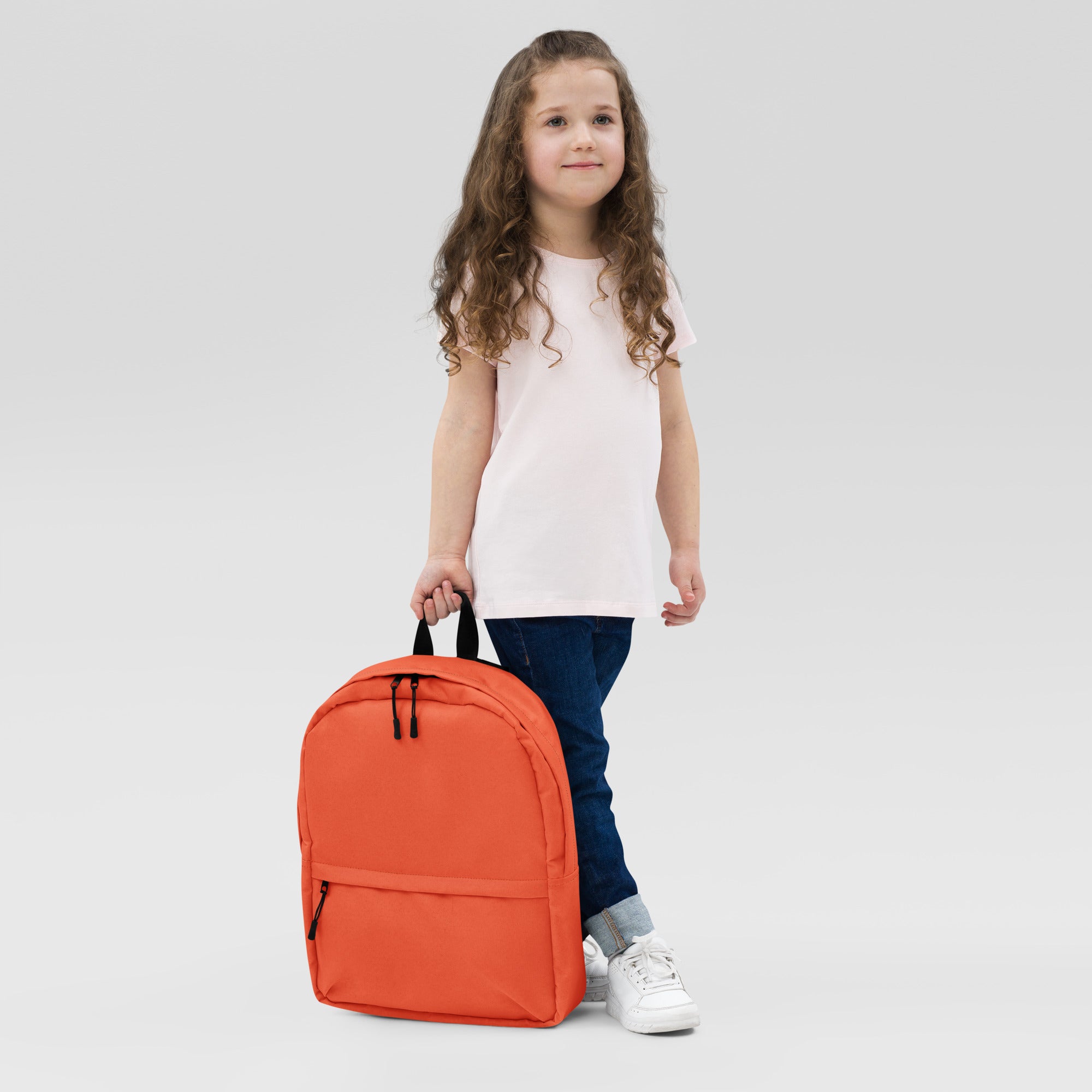 Kids orange backpack with black zippers and handles designed for durability and everyday use