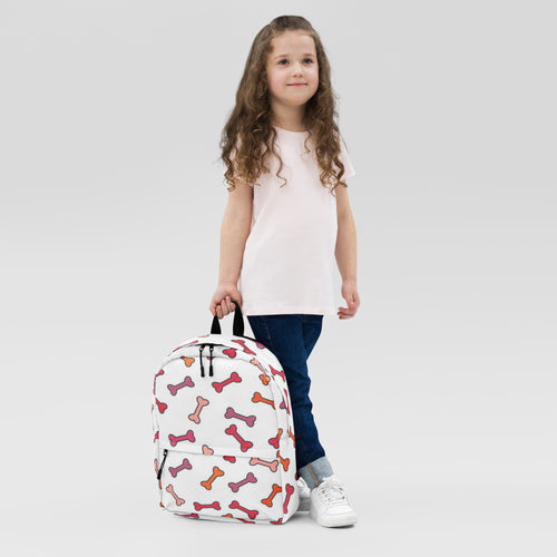 White girls backpack with playful multicolored pink orange and red dog bone pattern perfect for school use