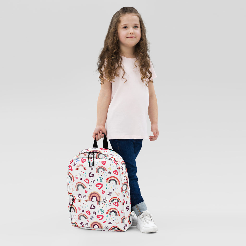 A white girls rainbow hearts doodle backpack with colorful rainbow and heart patterns on the front side