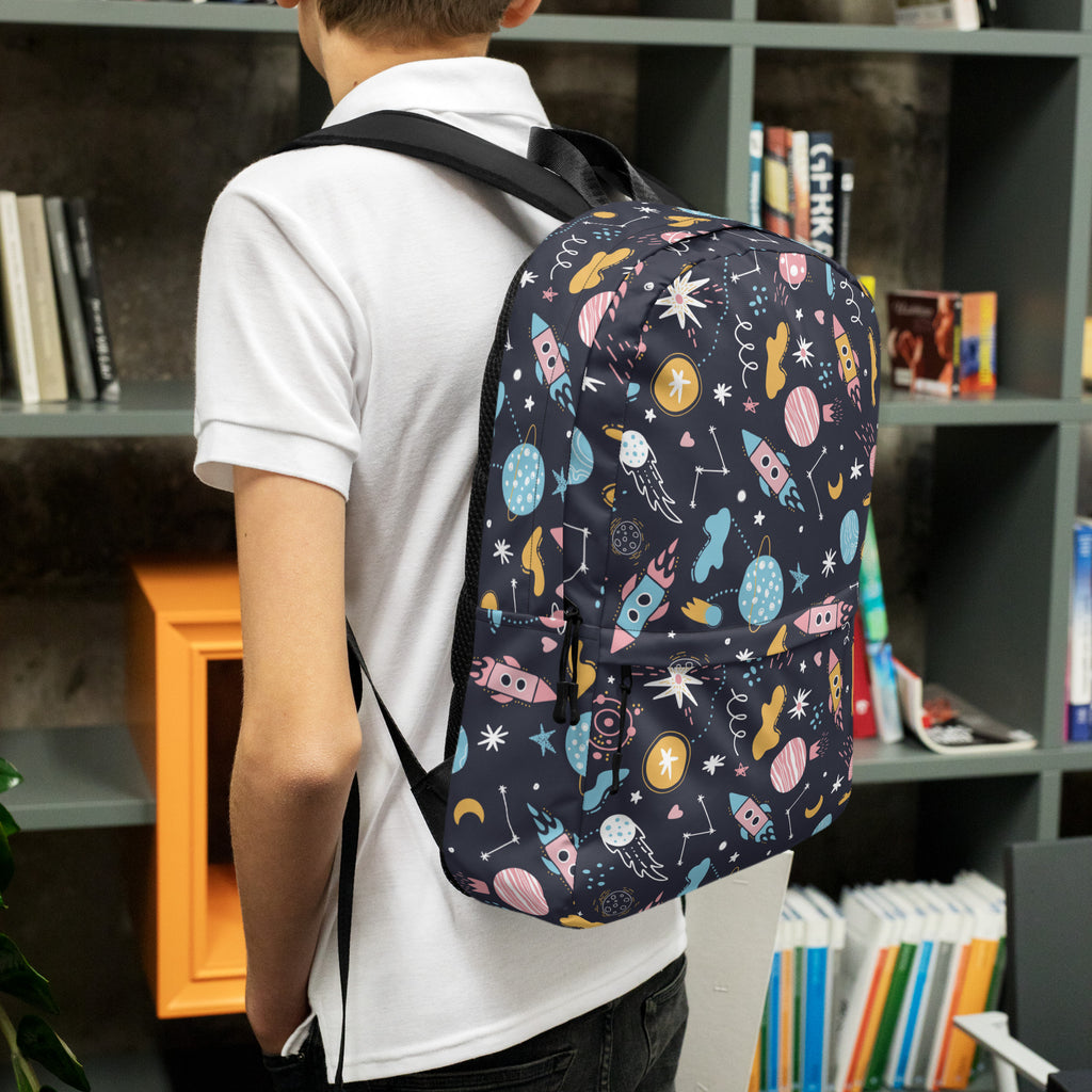 A navy blue kids outer space backpack with colorful pastel rockets planets and stars space-themed pattern