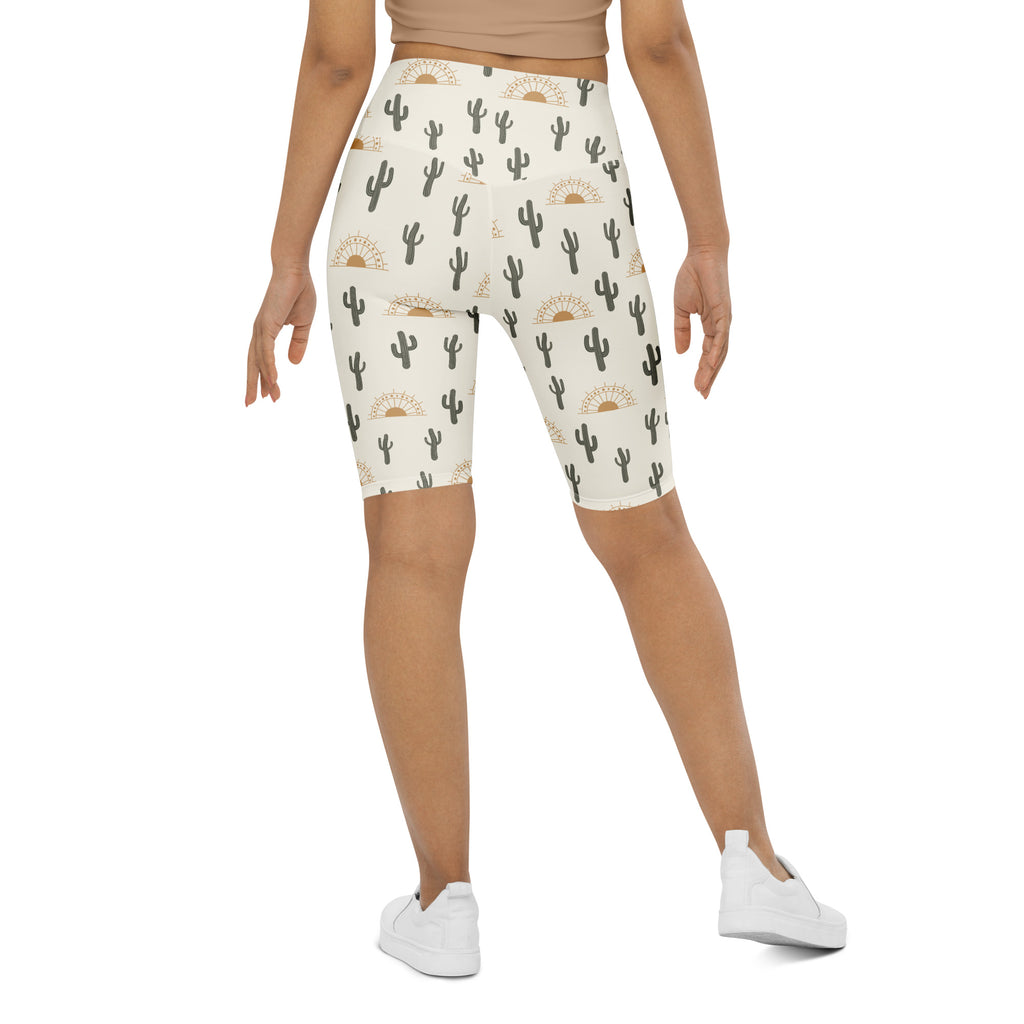 Cream-colored womens high waisted moisture wicking bike shorts with black cactus and gold sun pattern