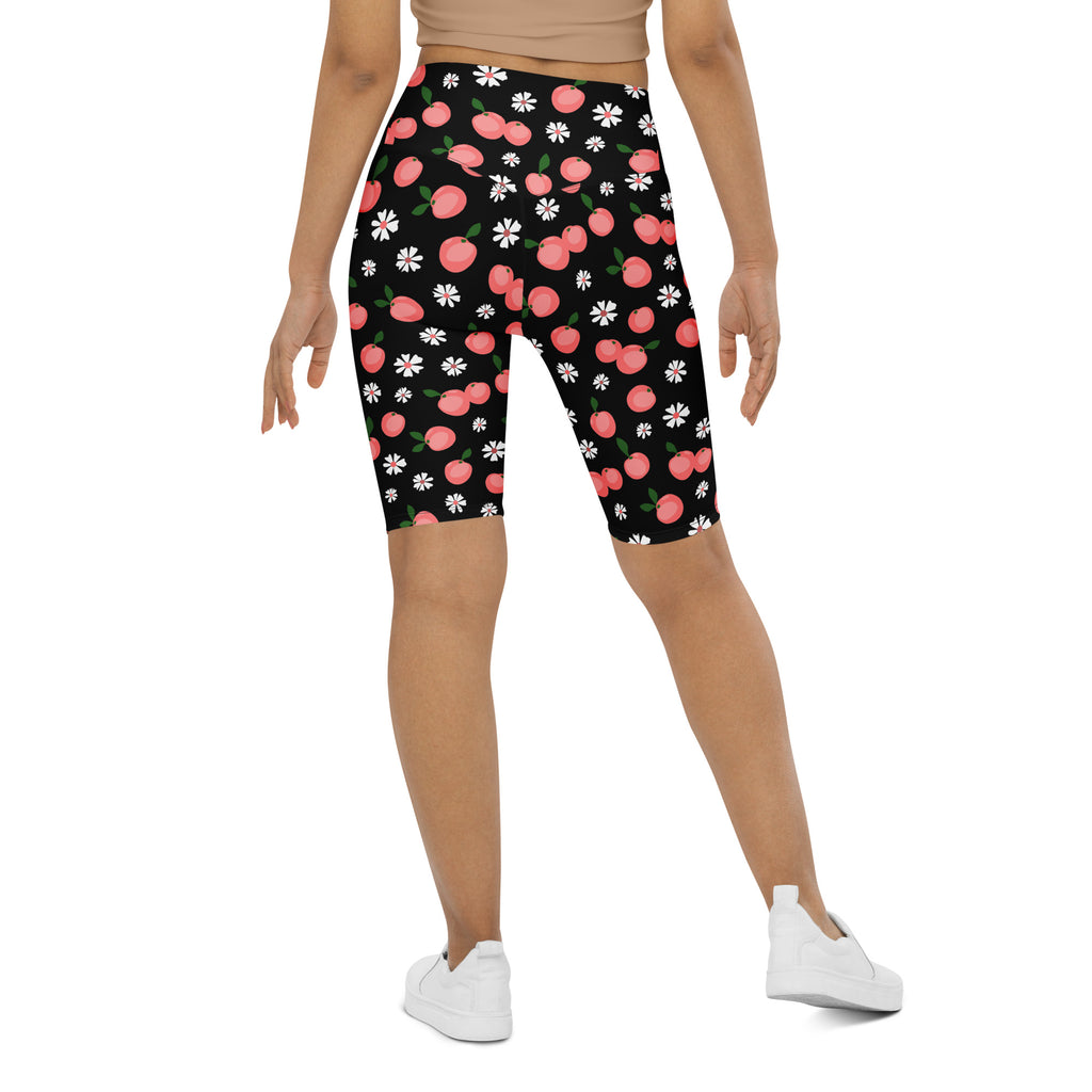 Women’s black high waisted moisture wicking bike shorts with pink peach and white daisy pattern for active fit