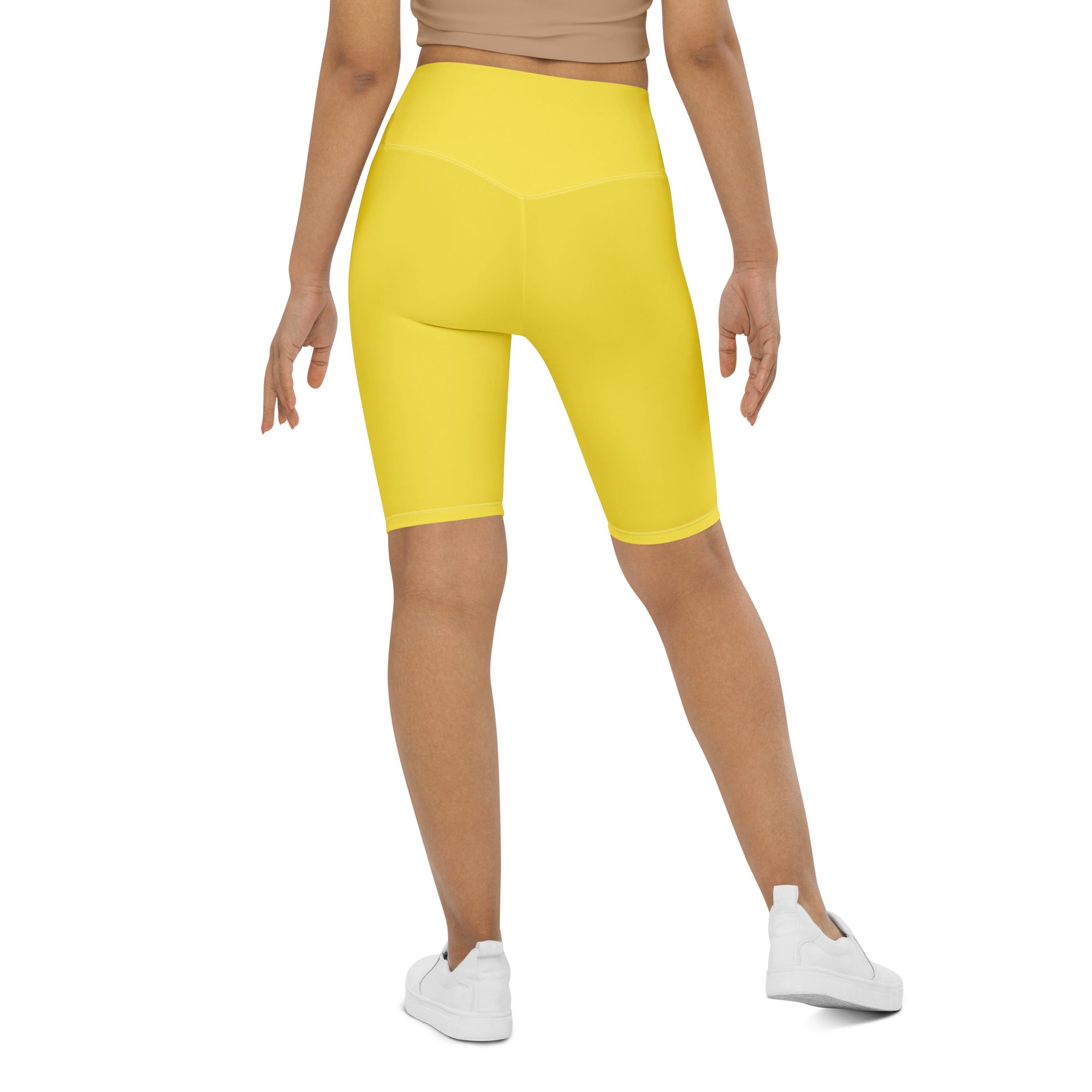 Bright yellow high waisted bike shorts made of stretchy moisture wicking fabric for active fit women