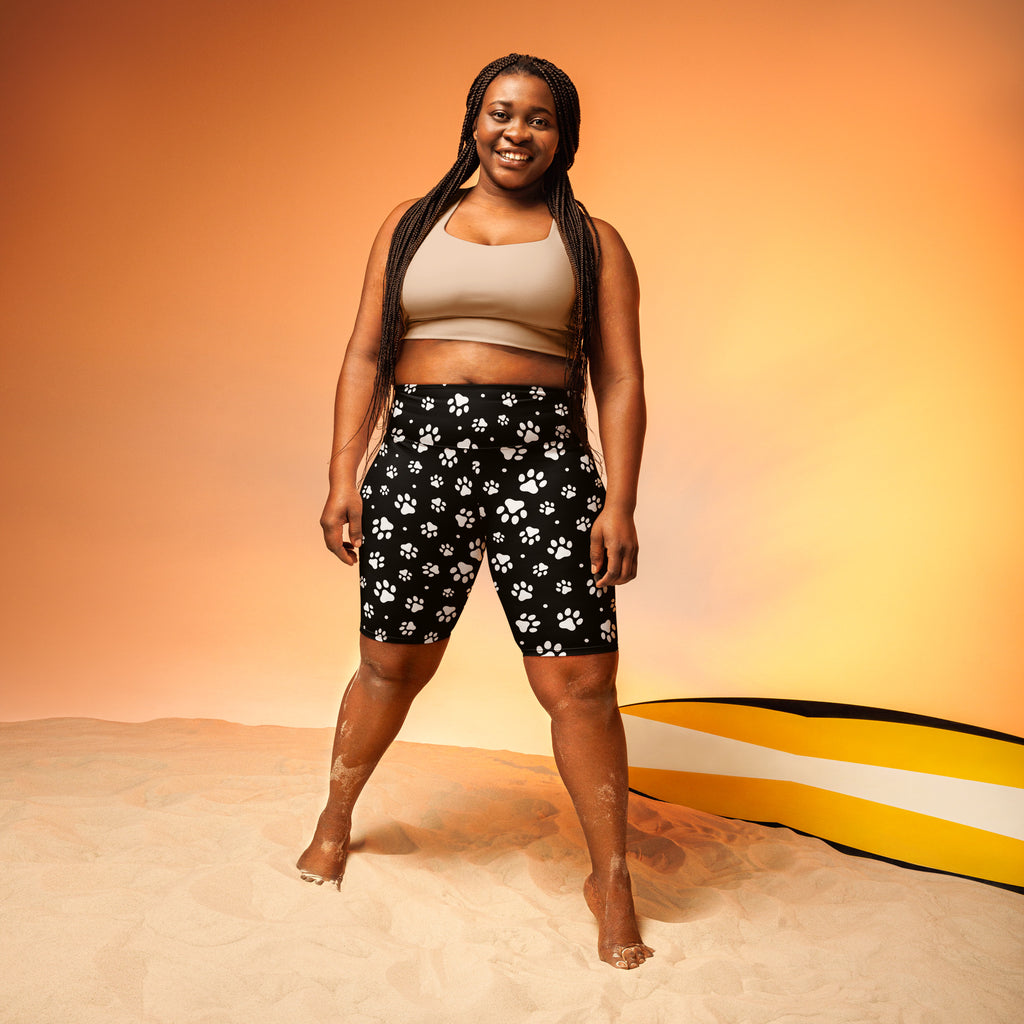 Black women’s high waisted biker shorts with white paw print pattern moisture wicking active fit front view