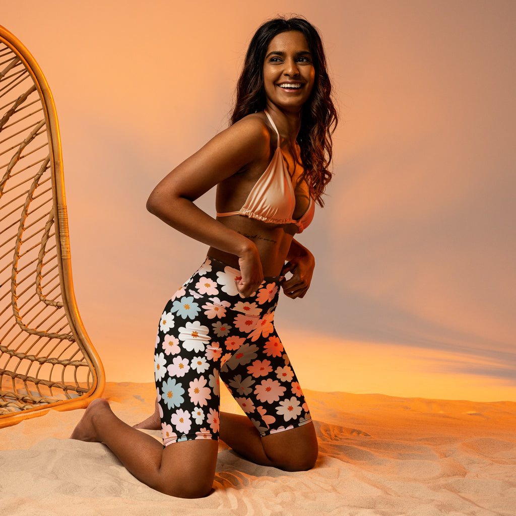 Black high waisted moisture wicking women’s biker shorts with vibrant pink white and light blue floral pattern