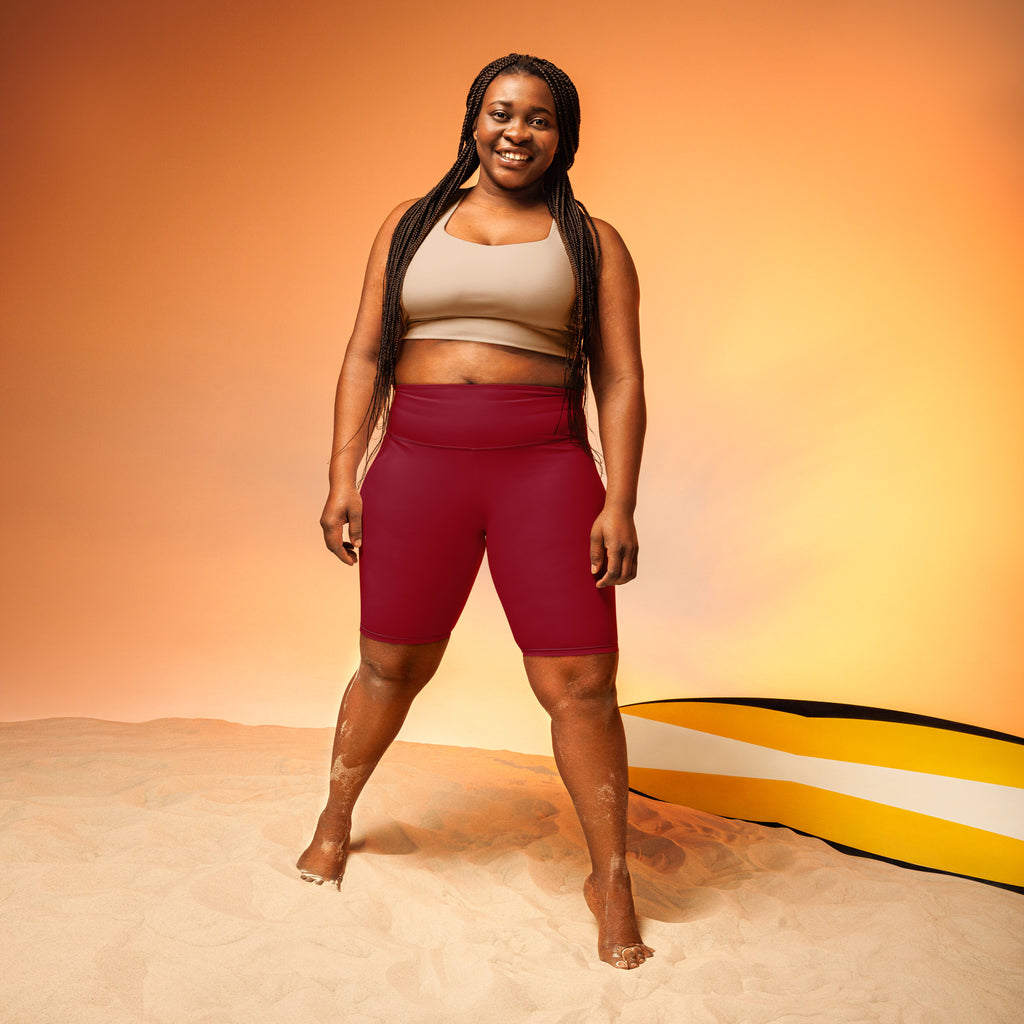 The model is wearing women’s burgundy high waisted biker shorts with moisture wicking, stretchy fabric for active fit