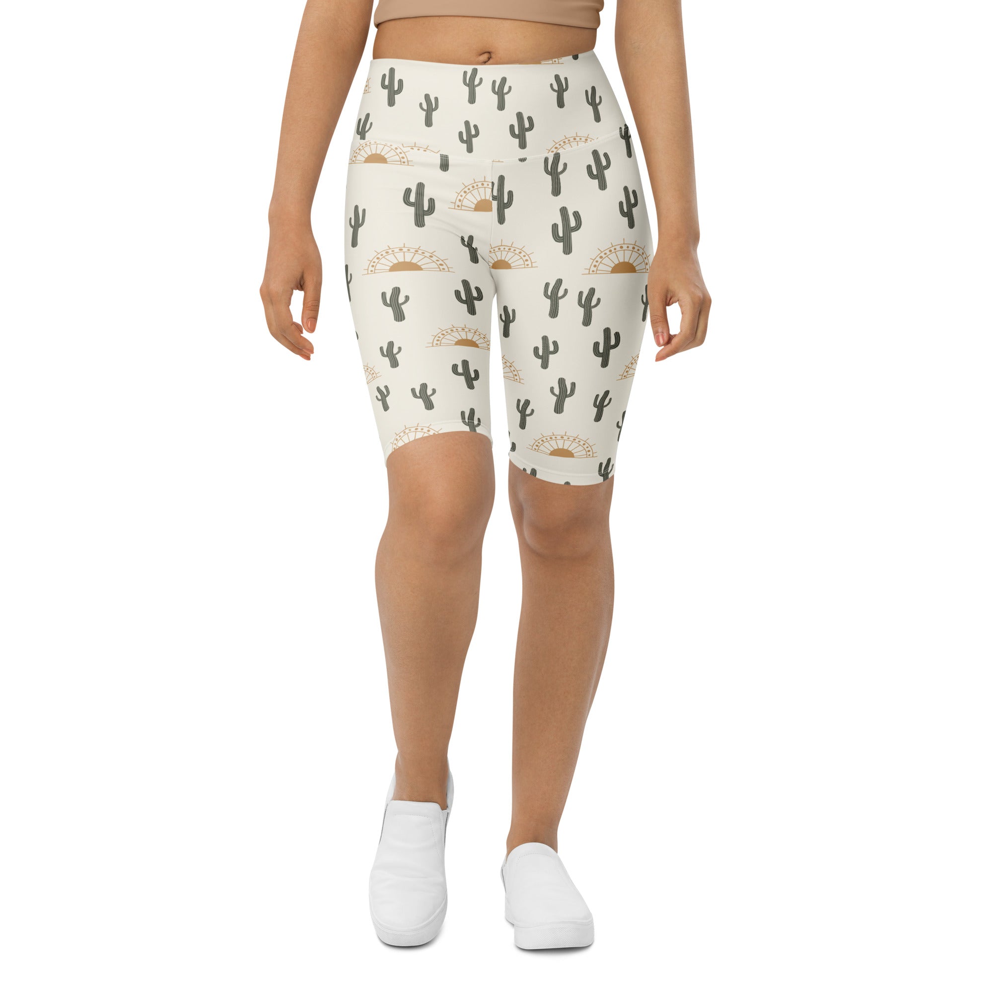Cream-colored women’s high waisted moisture wicking biker shorts with black cactus and gold sun pattern
