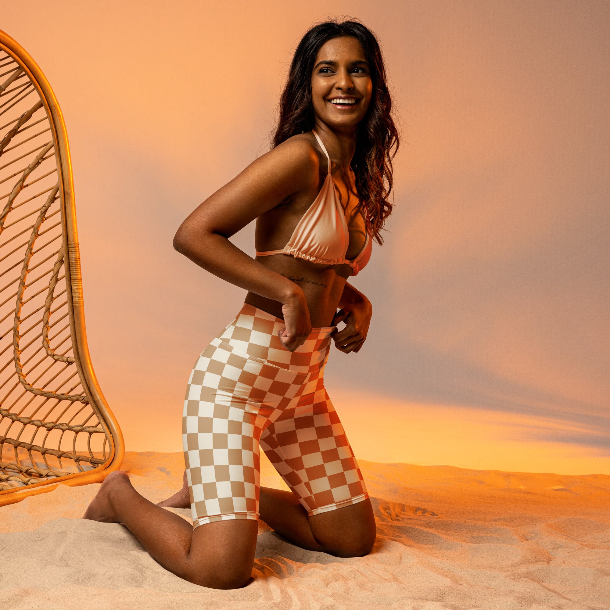 A woman wearing beige high waisted checkerboard biker shorts with moisture wicking active fit shown from the back