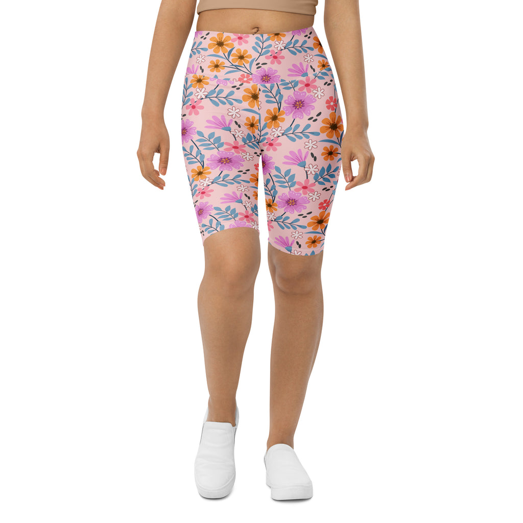 Women’s pink floral high waisted biker shorts with vibrant purple orange and blue blossoms moisture wicking fit
