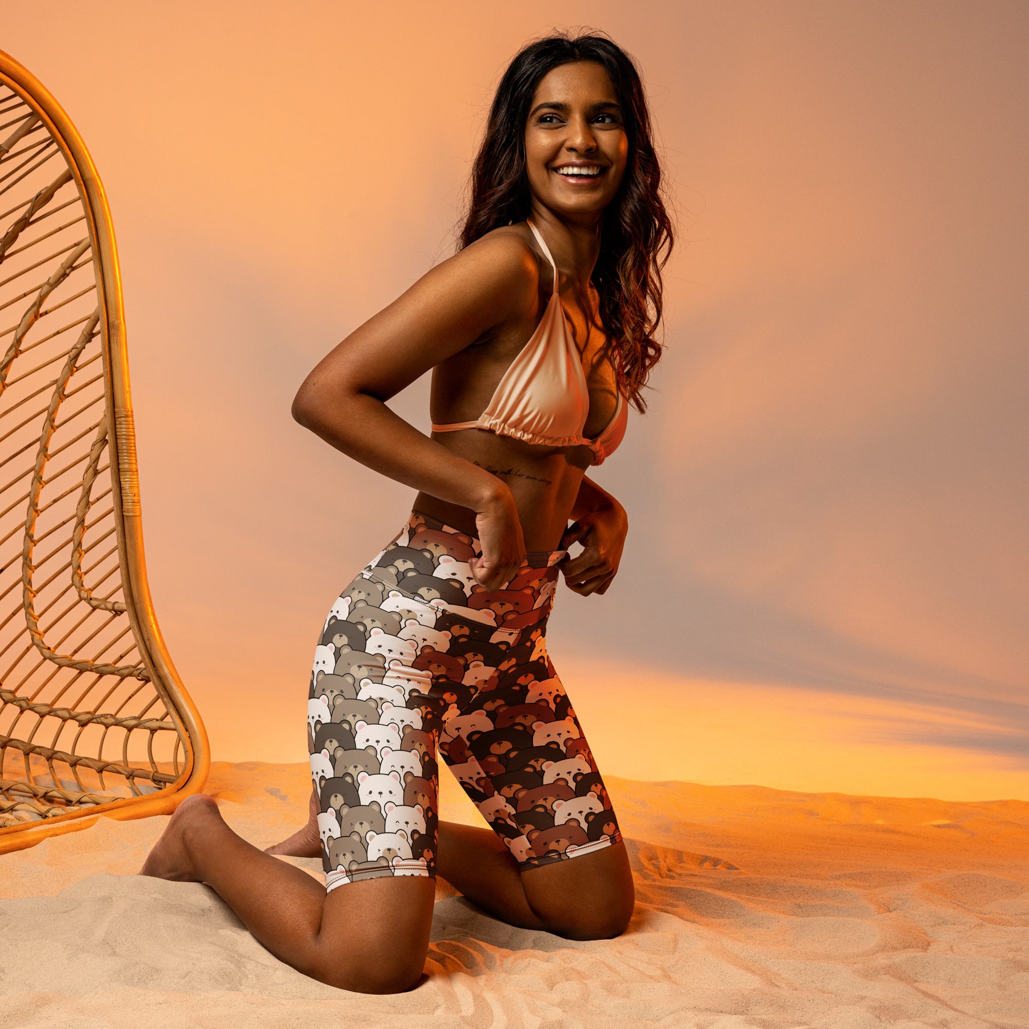 A woman wearing moisture wicking peach bikini top and high waisted biker shorts with playful cartoon bears pattern