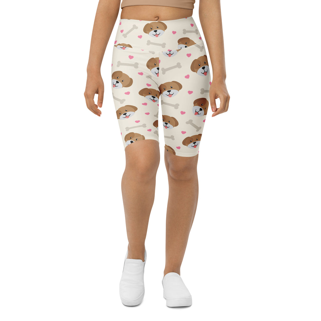 Cream-colored women’s high waisted biker shorts with moisture wicking fabric featuring puppy faces hearts and bones pattern