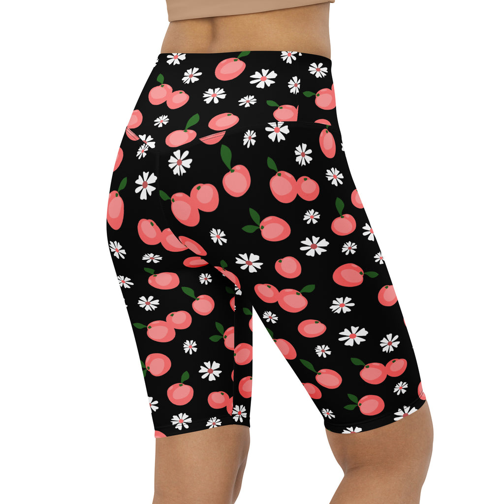 Women’s black high waisted moisture wicking biker shorts with pink cherries and white daisies pattern