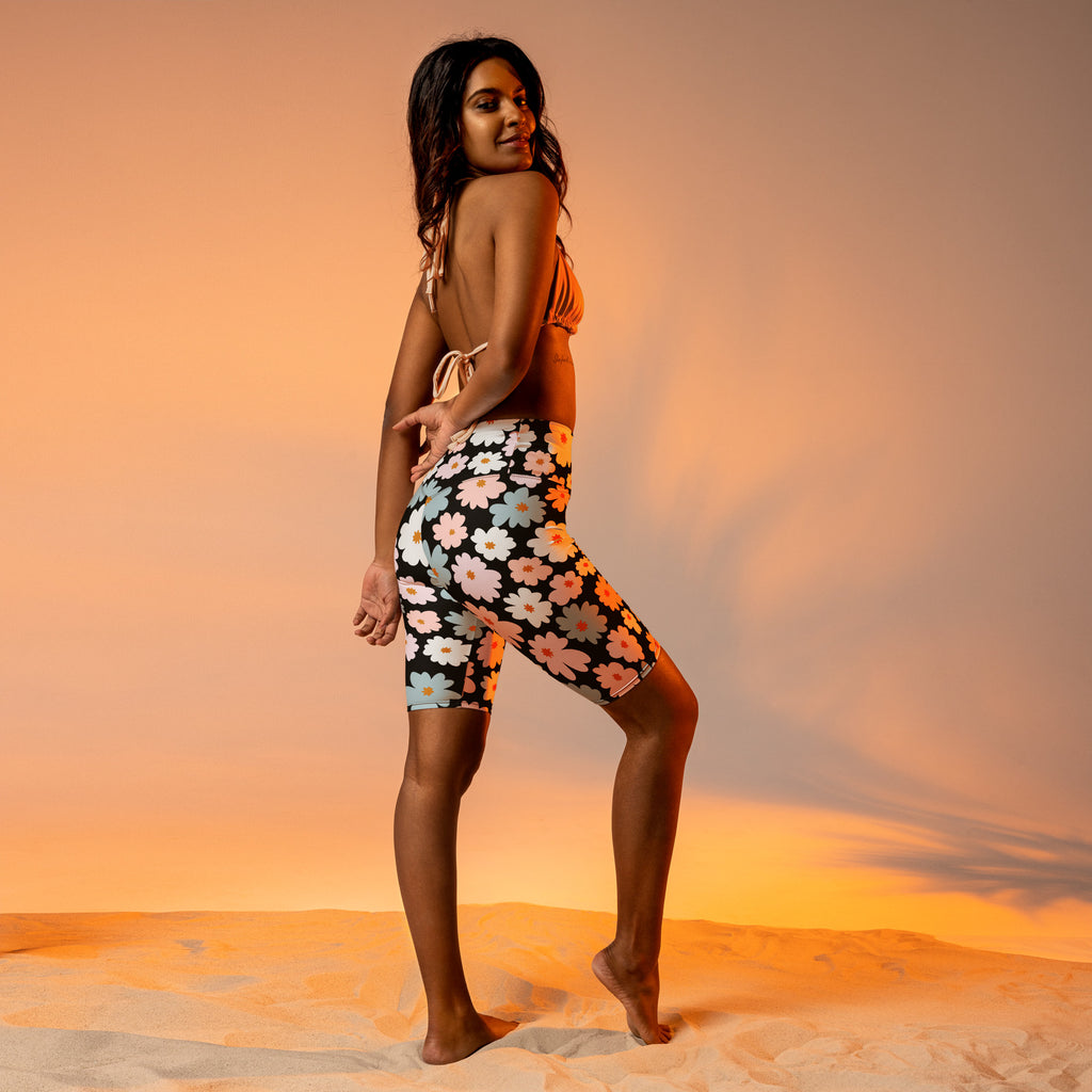 Women’s retro floral high waisted biker shorts with moisture wicking black fabric and pink white blue daisy pattern