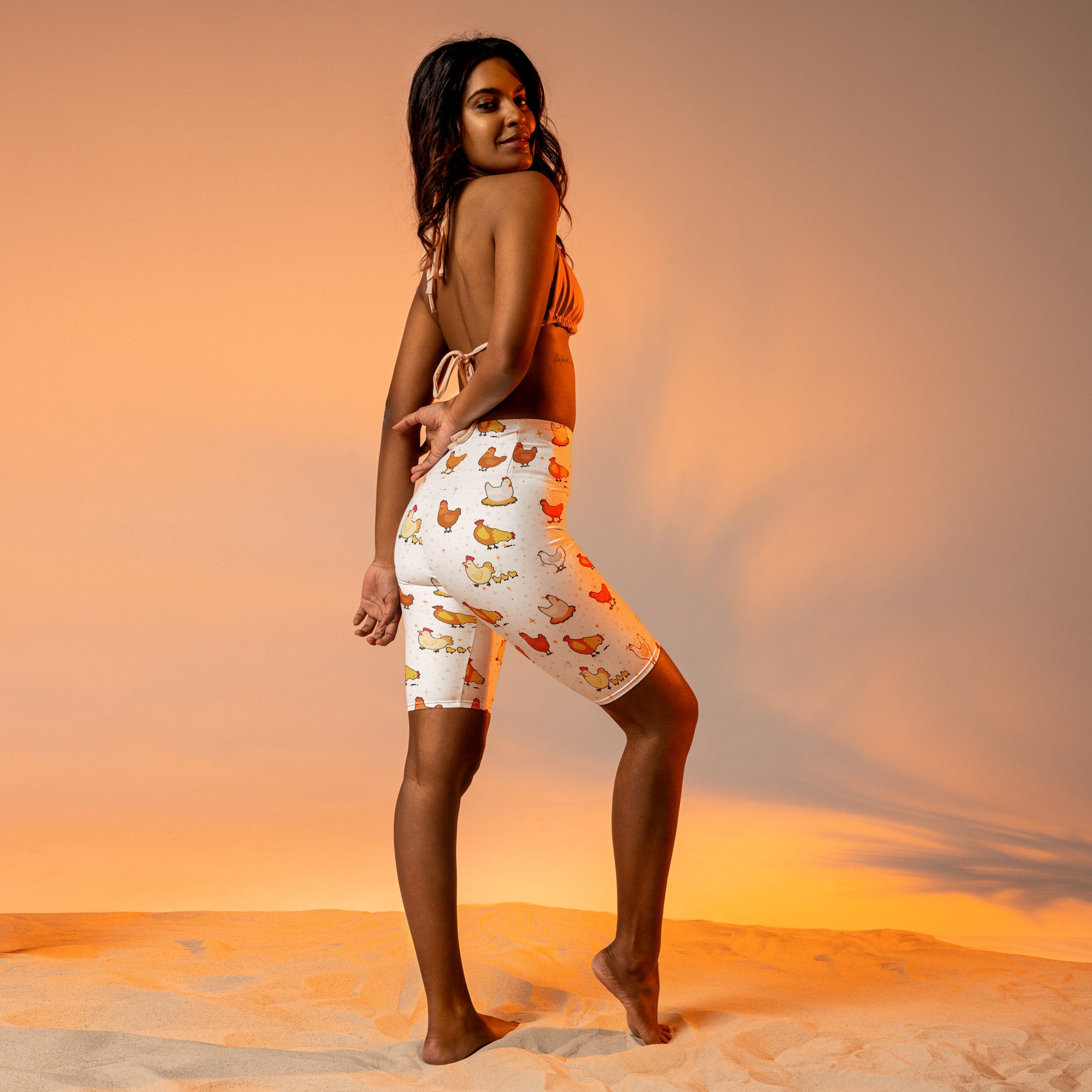 Women’s white high waisted moisture wicking bike shorts with playful orange and brown cartoon chicken pattern
