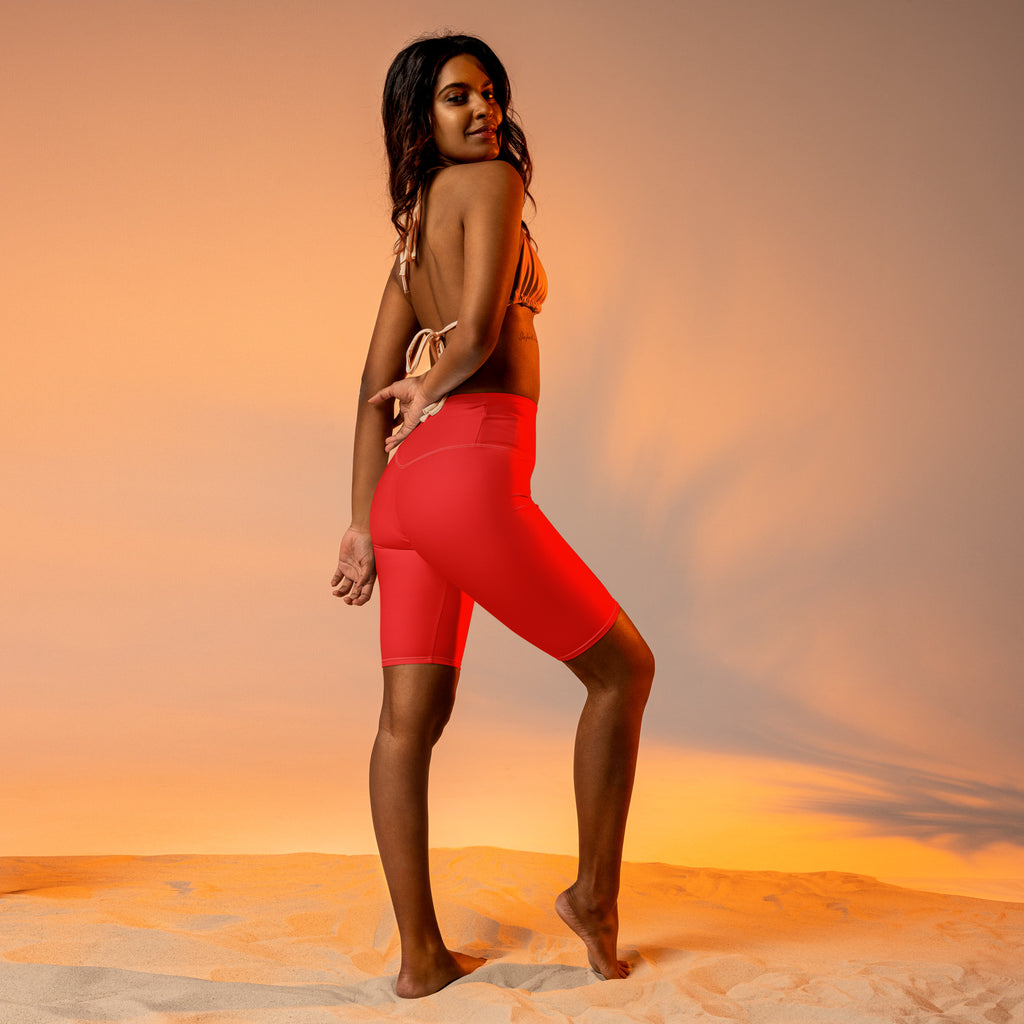 Bright red women’s biker shorts with high waist moisture wicking fabric and side pockets for active fit use