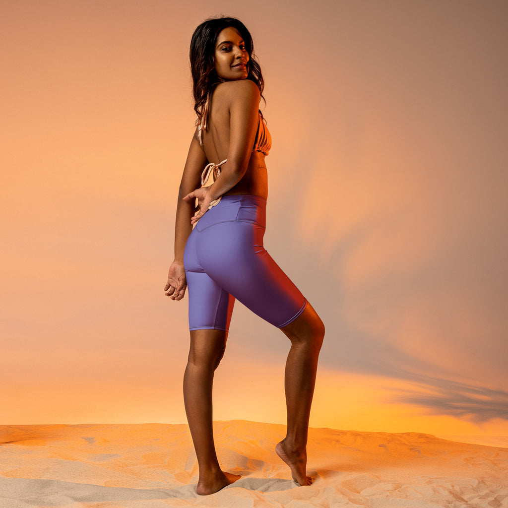 Women’s purple high waisted biker shorts with moisture wicking fabric and a sleek form fitting active fit design