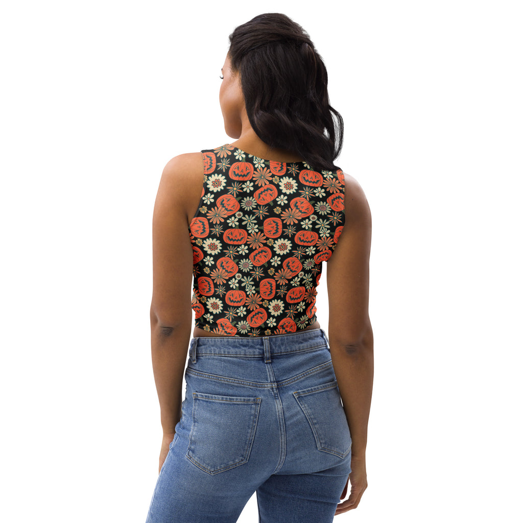 A black sleeveless buttery soft crop top with vibrant orange jack-o lanterns and white daisies for halloween