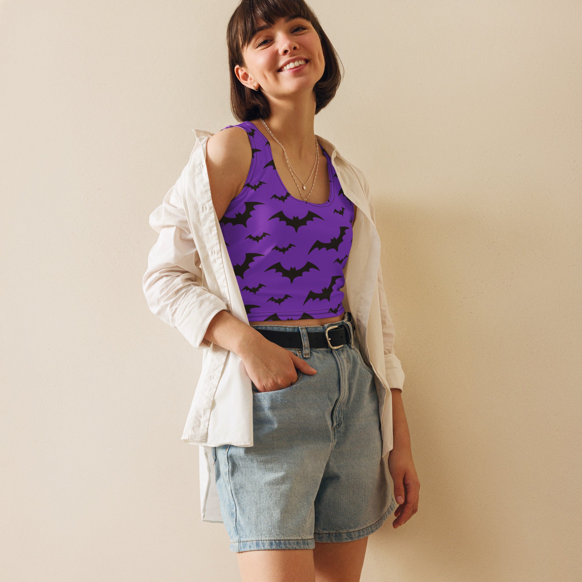 Women’s purple bats halloween buttery soft crop top in bat pattern worn with denim shorts and white shirt