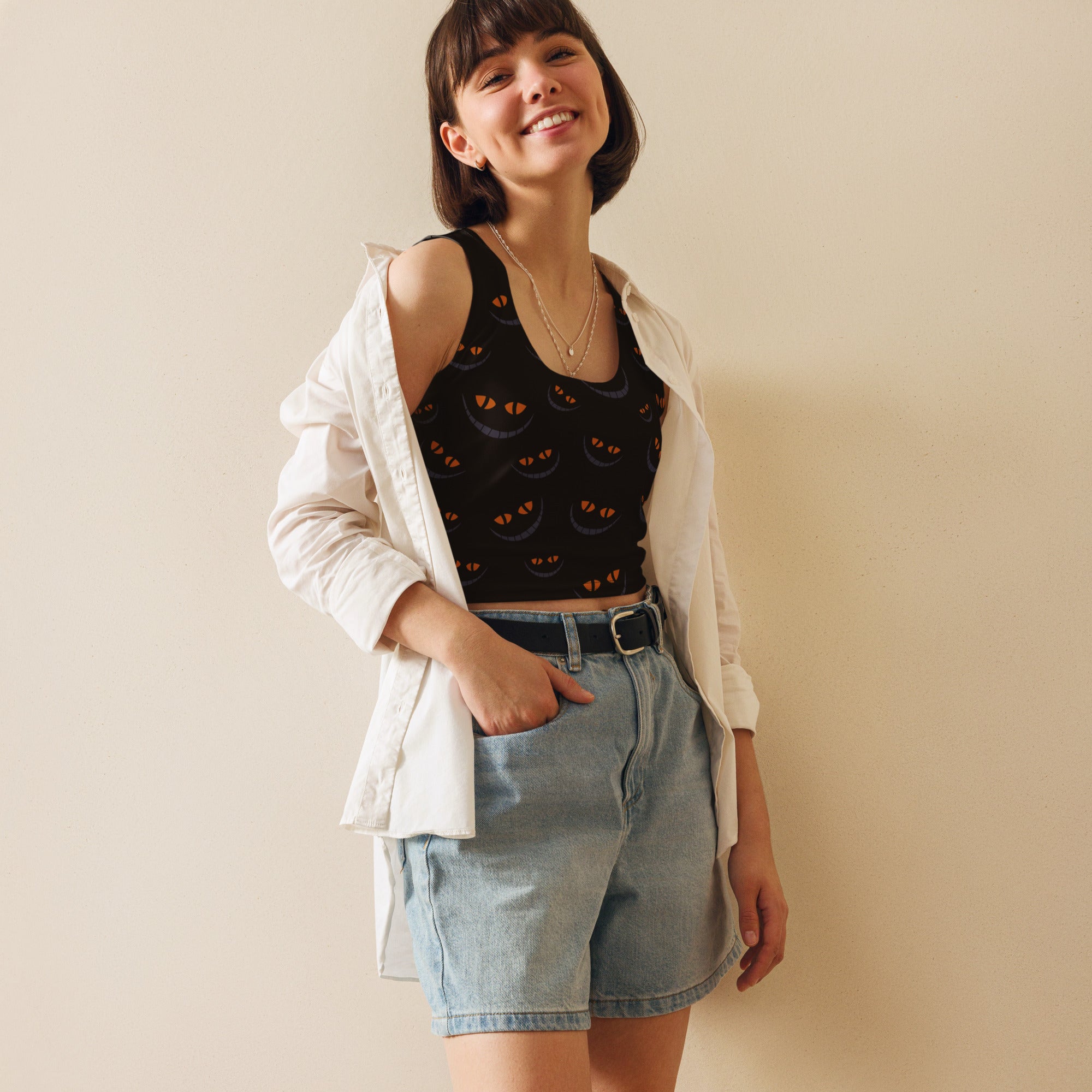 Women’s black buttery soft crop top with orange cat eyes print shown under a white button-up shirt