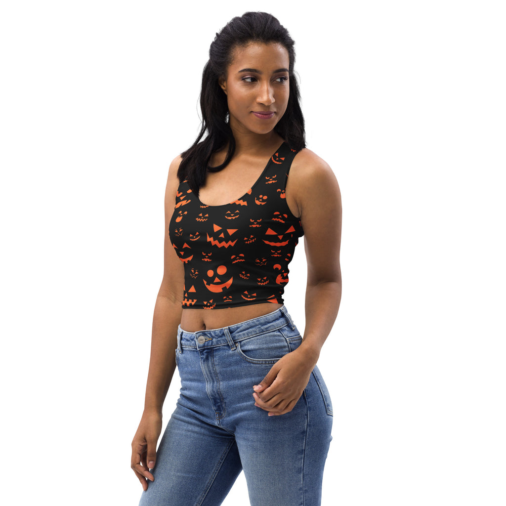 Women’s black buttery soft crop top with orange jack o lantern faces printed for halloween wear